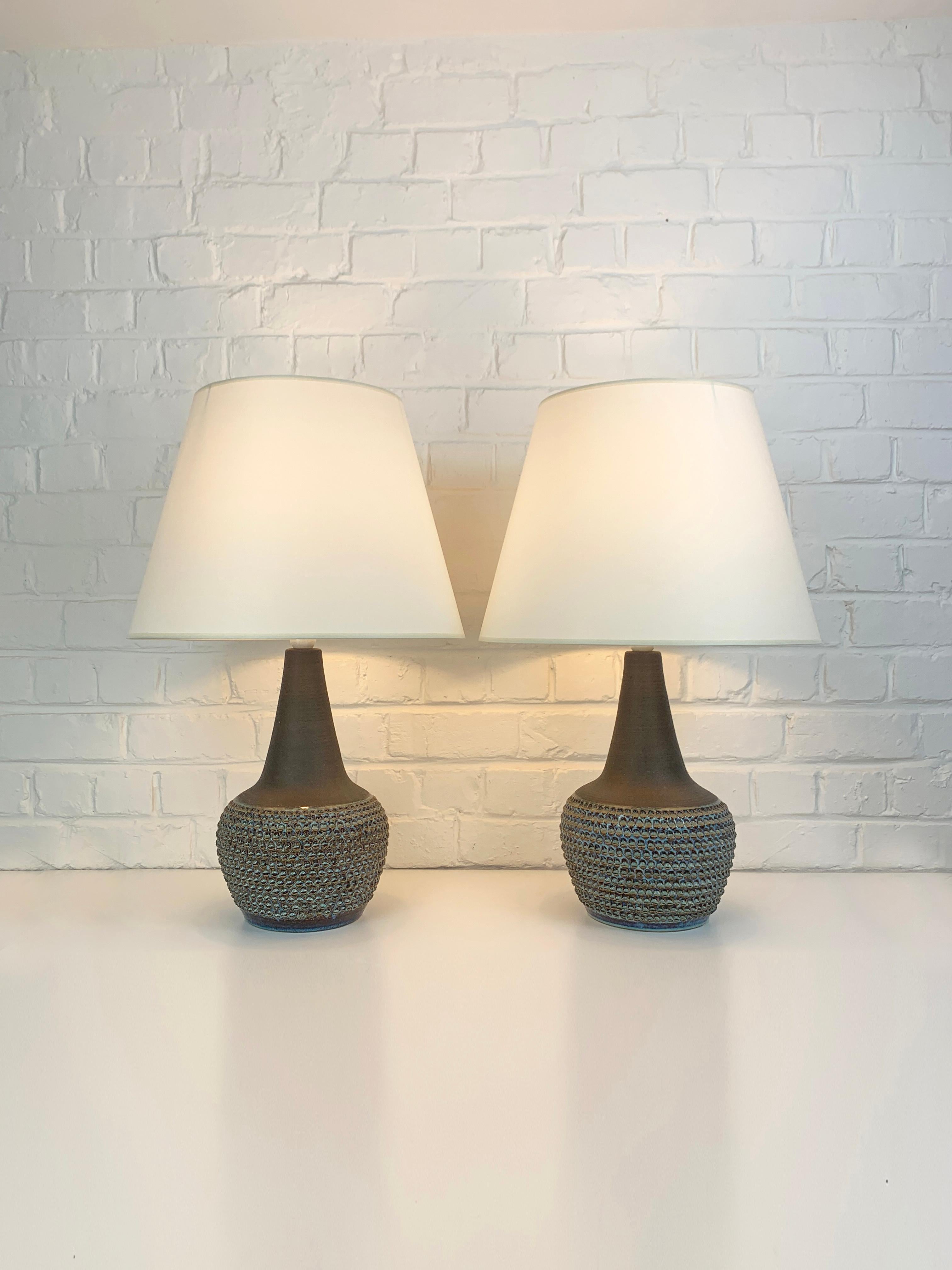 Paire de grandes lampes de table danoises en grès du milieu du siècle dernier des années 1960-70.   

La partie inférieure des lampes est décorée d'un motif imprimé, émaillé en bleu foncé et clair avec des accents ocre/gris. La partie supérieure