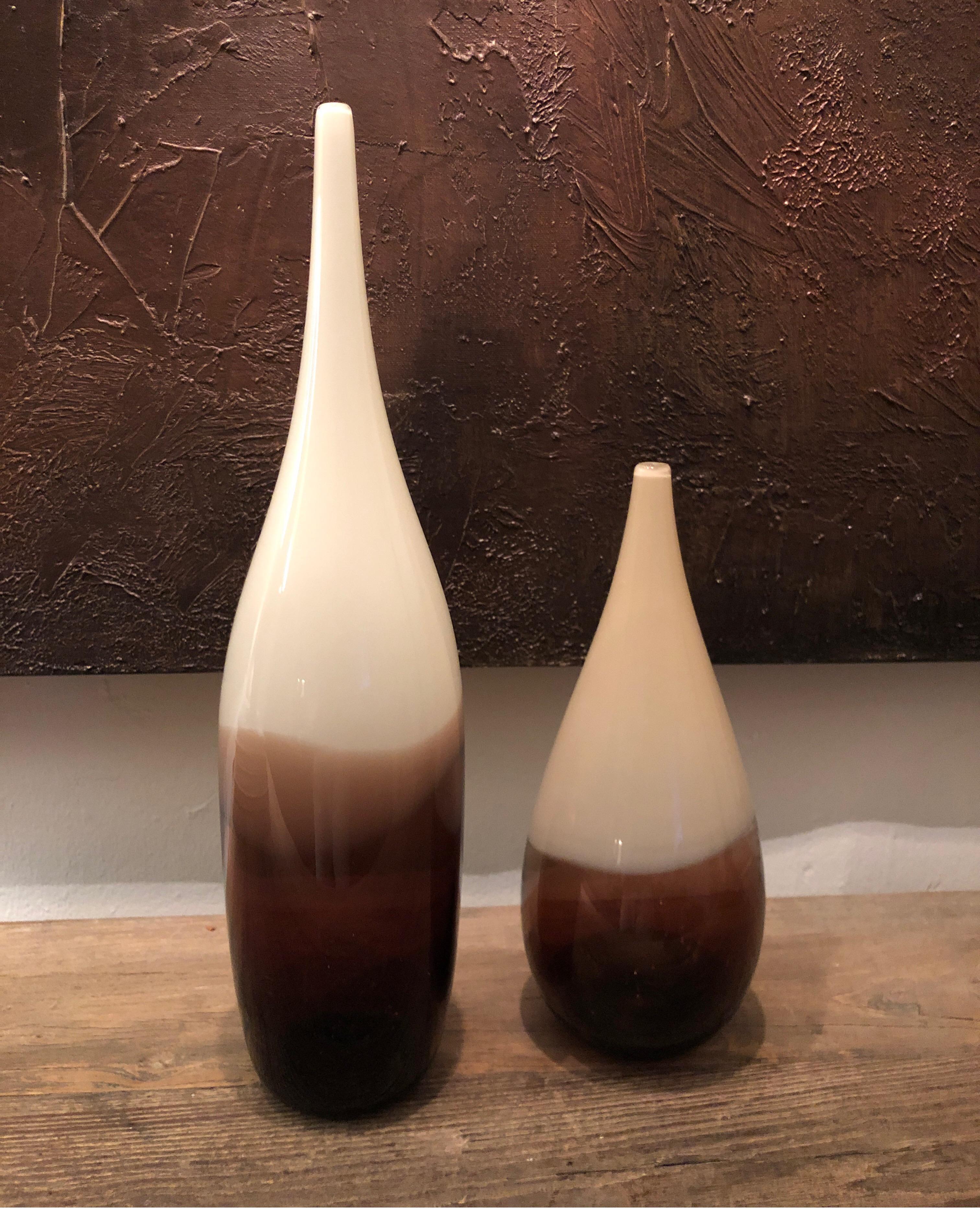 Pair of hand blown and shaped in lead free crystal. Murano inspired glass with transparent white/off-white and amber layers.
One vase measures 16