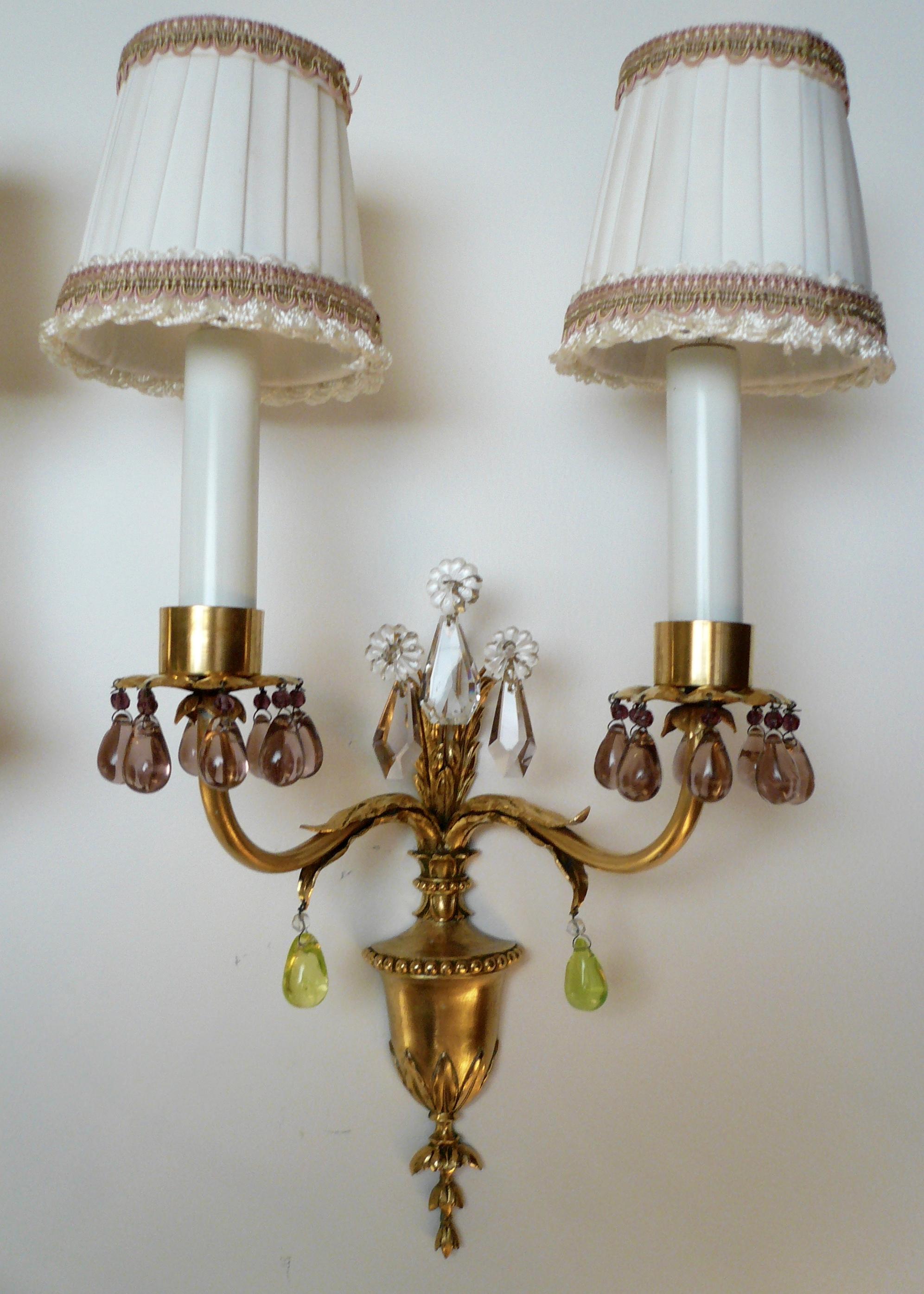 These beautiful Caldwell sconces feature Classical motifs including bellflowers and acanthus leaves. They are hung with the original amethyst and citrine colored prisms.
 