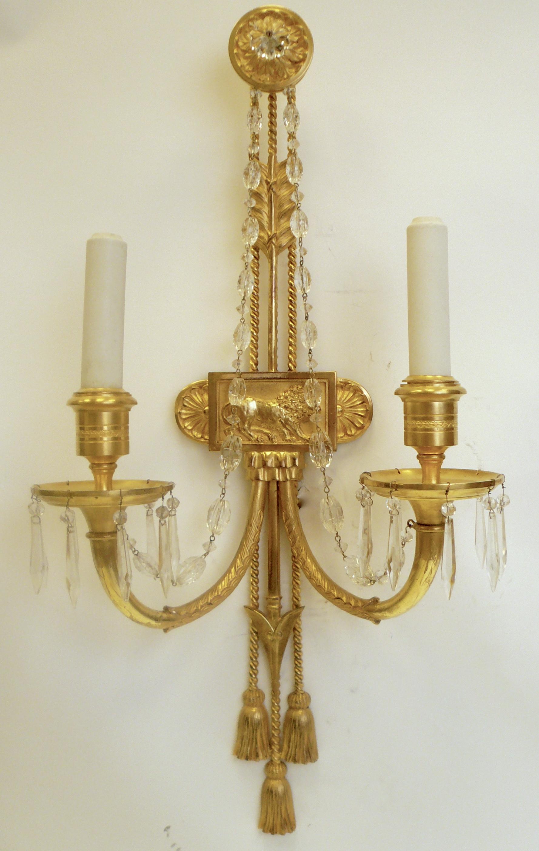This impressive pair of Empire style 'lion' sconces are by Edward F. Caldwell.
They feature Classical motifs including acanthus leaves, arrows, rosettes, and roped tassels. They retain the original gilt bronze finish, and have been newly re-wired.