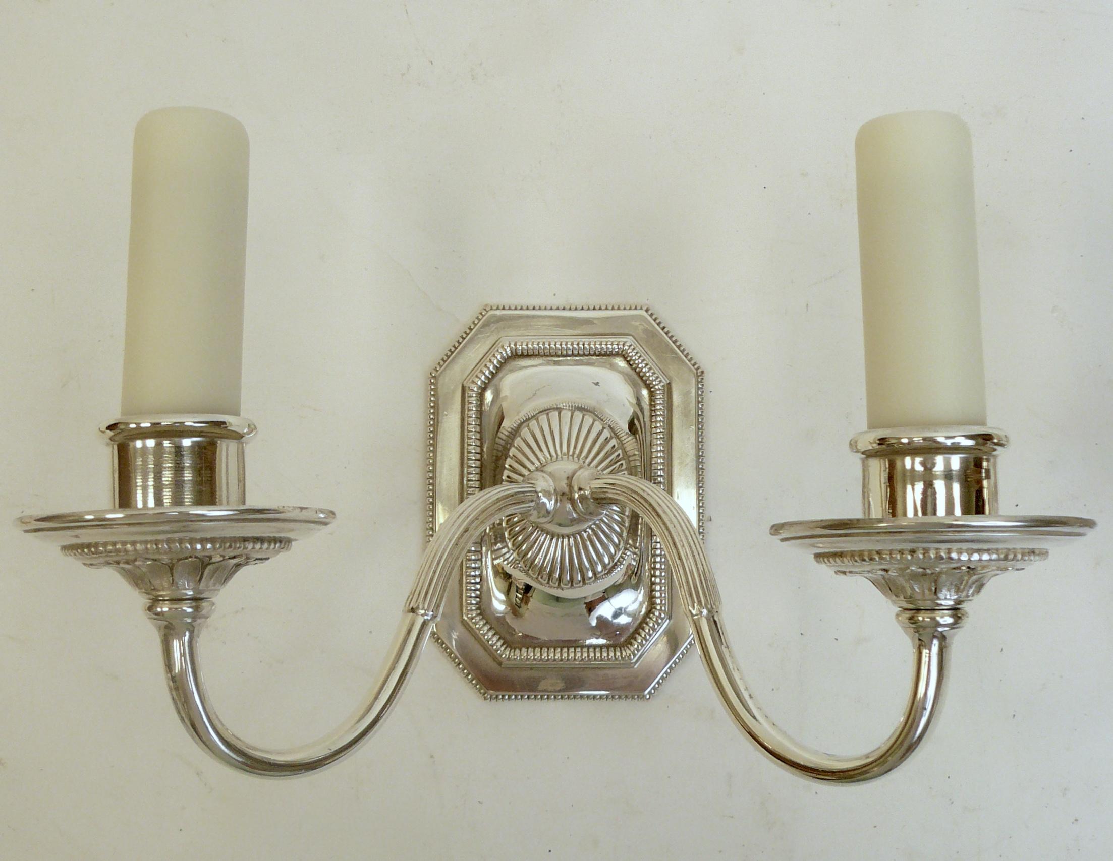These handsome George III style sconces by renowned maker Edward F. Caldwell feature Classical motifs, including acanthus leaves, and beaded borders.