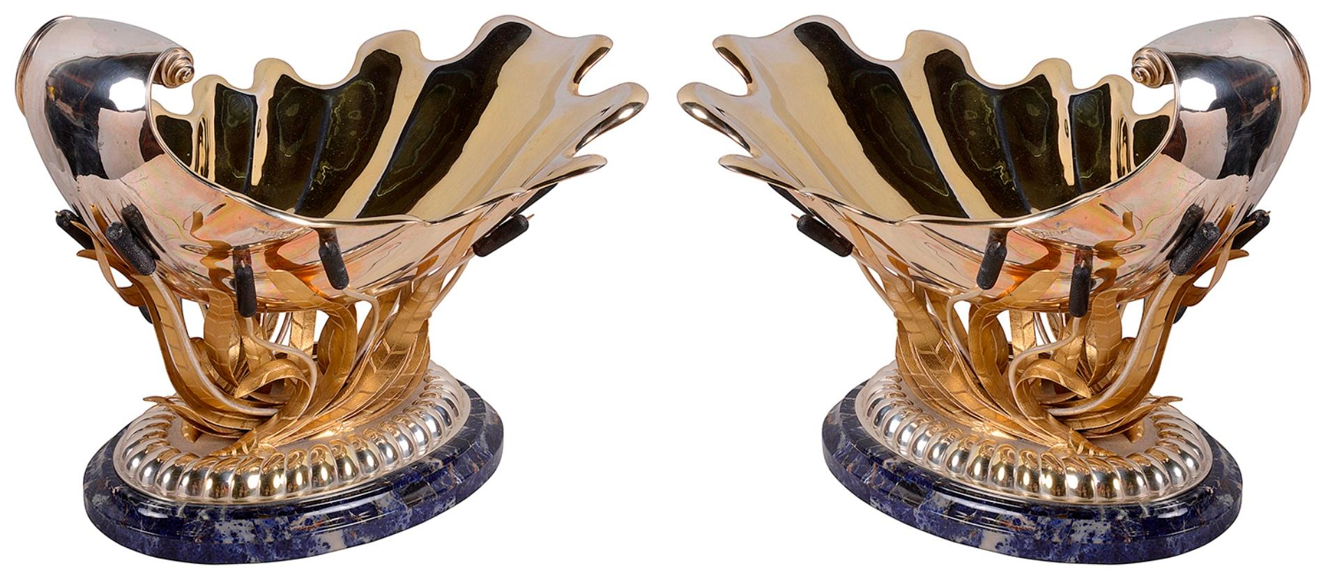 A wonderful fine quality pair of silver gilt sea shell jardinieres, raised on swirling bulrushes and mounted on hardstone bases. Measures: 45cm(18