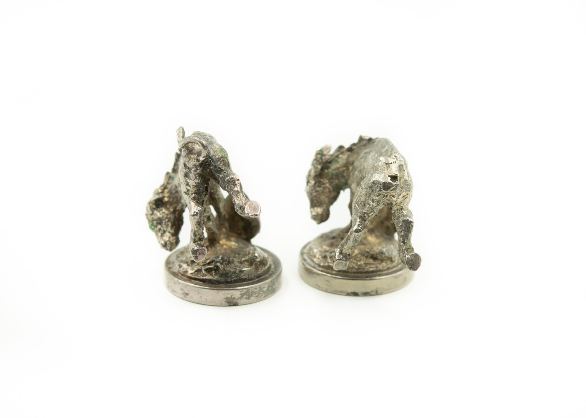 Highly stylized pair of vintage silver plate donkey menus, place cards, or card holders. Great detail to their facial expressions and bodies. There is a clip attached to the base to hold a menu or place card.
One donkey is missing his tail.
 