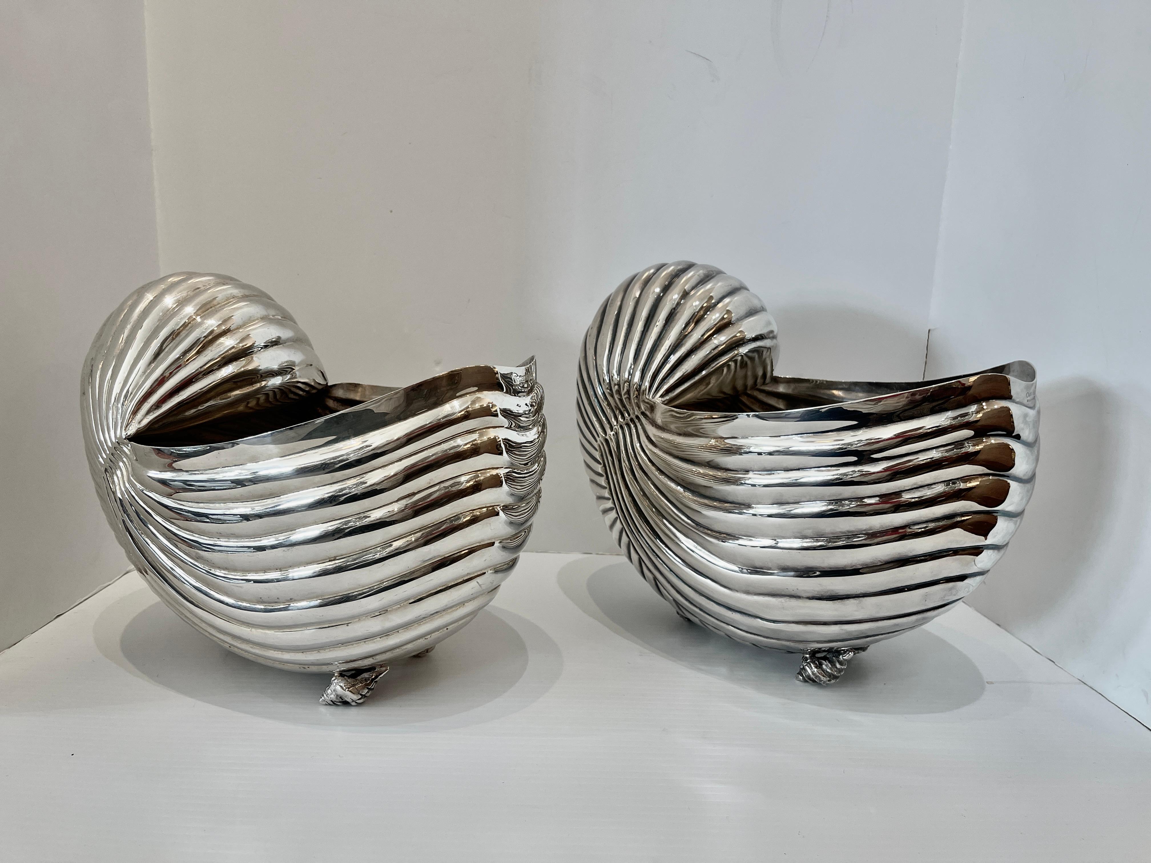 This is a great set or pair,  of two Nautilus Shell bottle coolers or cachepot.
They are a pair but  slightly different as they are hand made.
They are ribbed and hey stand on three small conch shells .
Very good vintage condition, the Silver is in