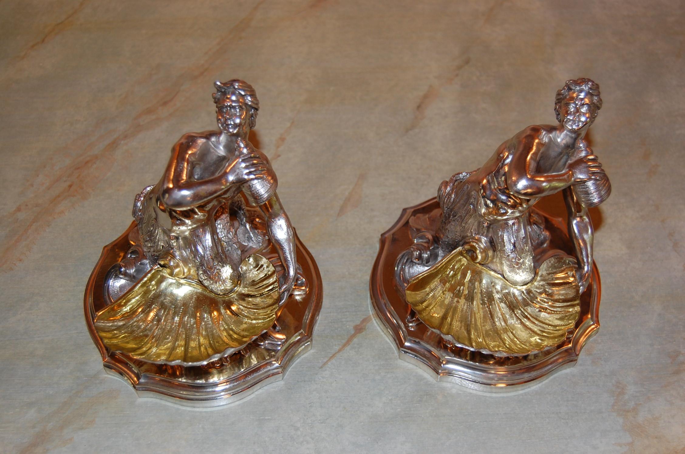 19th century pair of identical silver plated bowls feature a male mermaid or Neptune with twin fish tails, holding a seashell and supporting a larger scallop with gilt interior. Recently cleaned, polished and lacquered and in excellent condition.