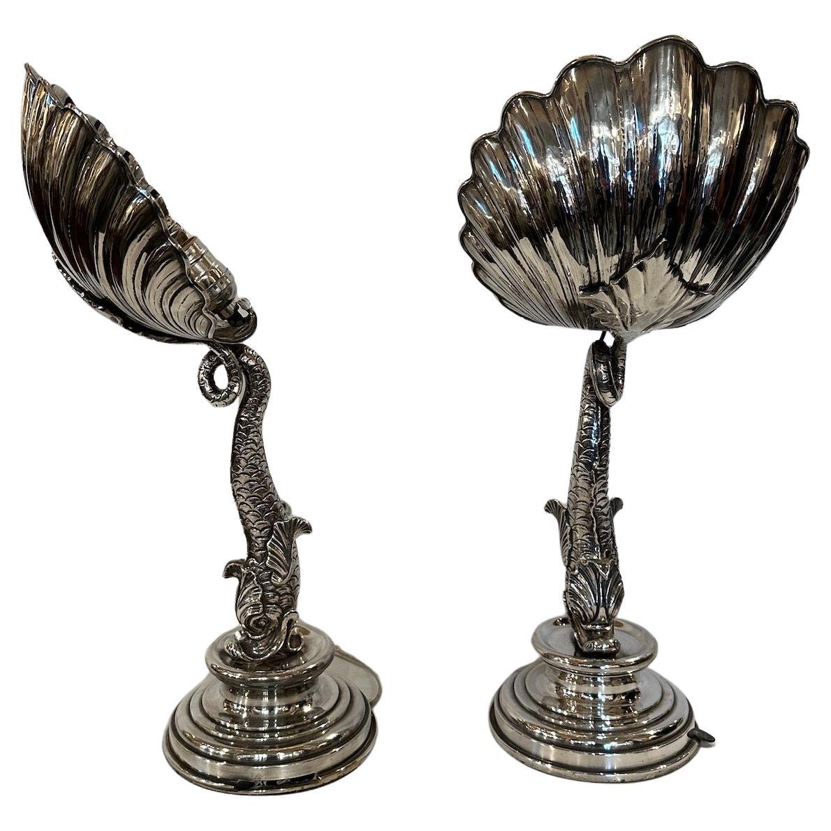 Pair of silver-plated up lights featuring a shell supported by a dolphin on a stepped base.  Electrified for USA.  