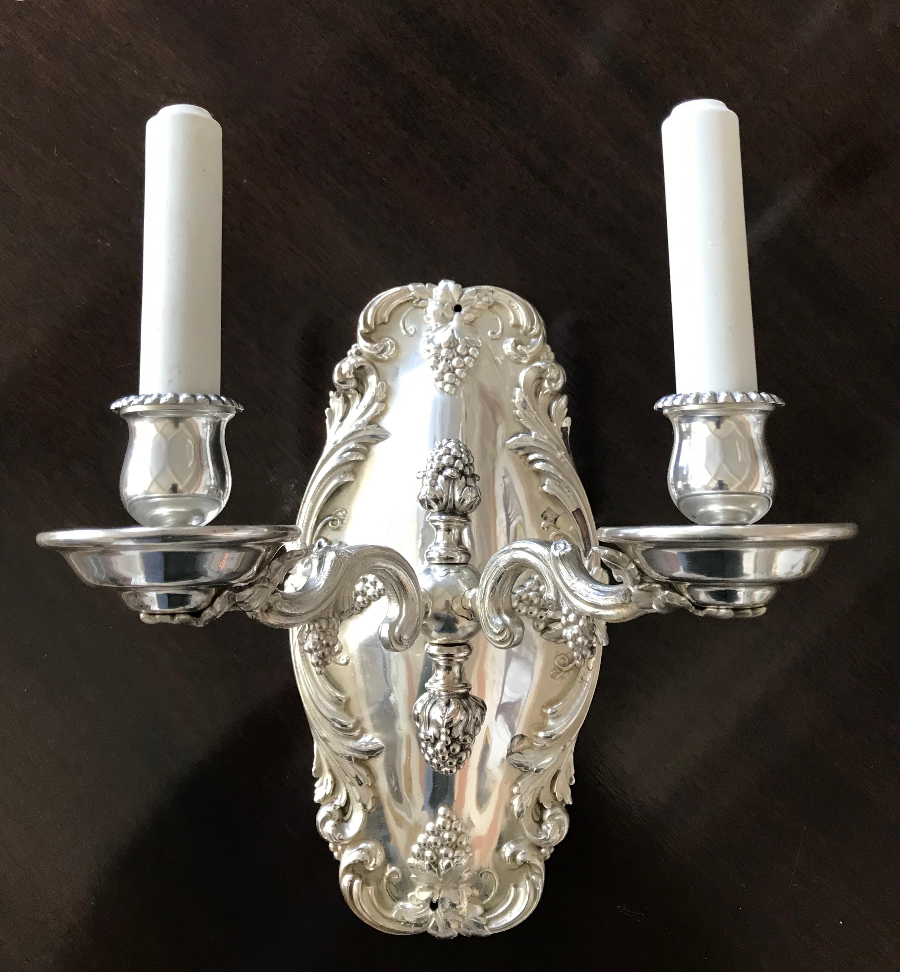 This impressive pair of signed Caldwell silver sconces feature vintage motifs including grapes, vines and leaves. They have been newly rewired and are ready for use.