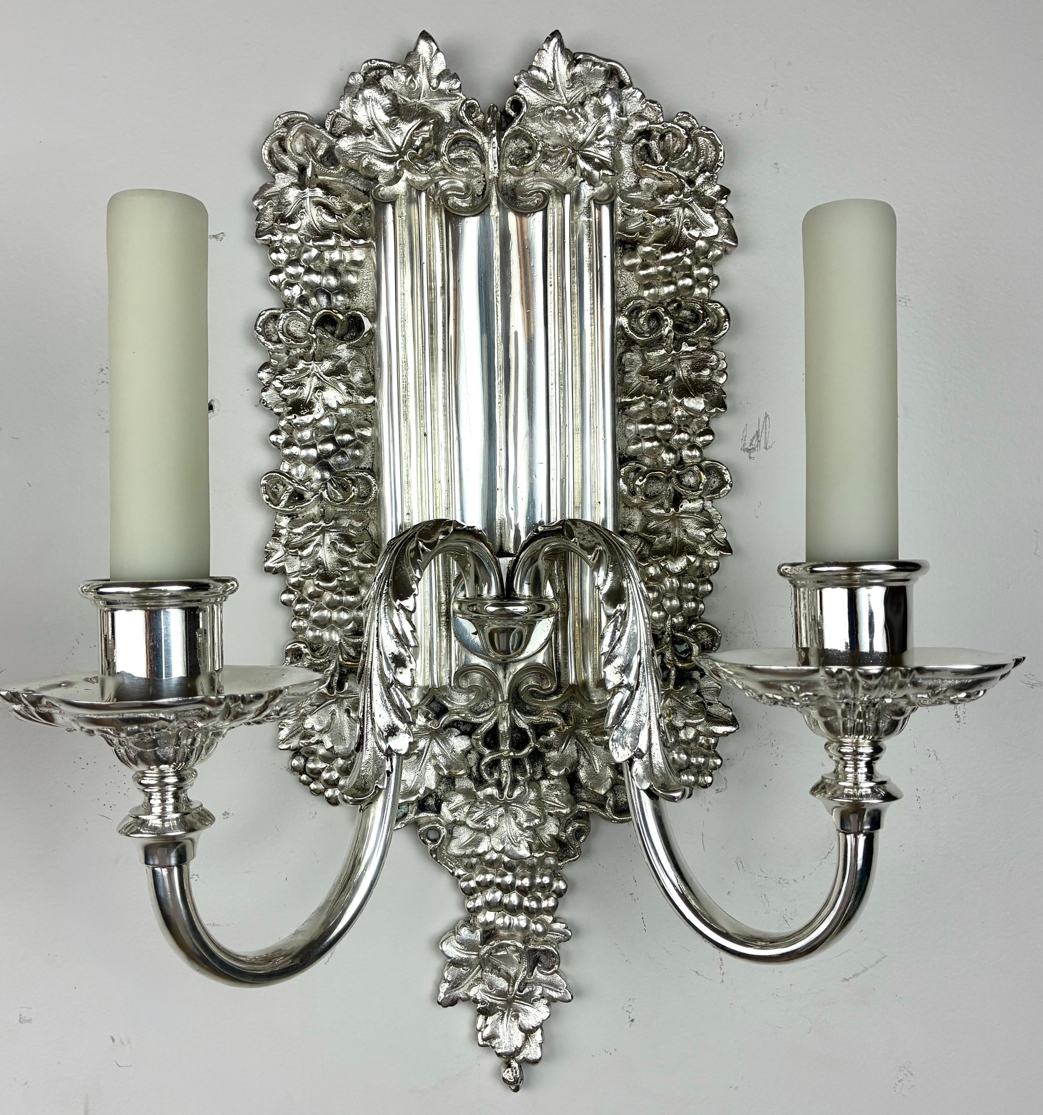 Este par de apliques de bronce plateado de estilo georgiano temprano presenta placas traseras de diseño de pliegues de líneas con uvas y motivos de época.
Son de la renombrada firma Edward F. Caldwell.