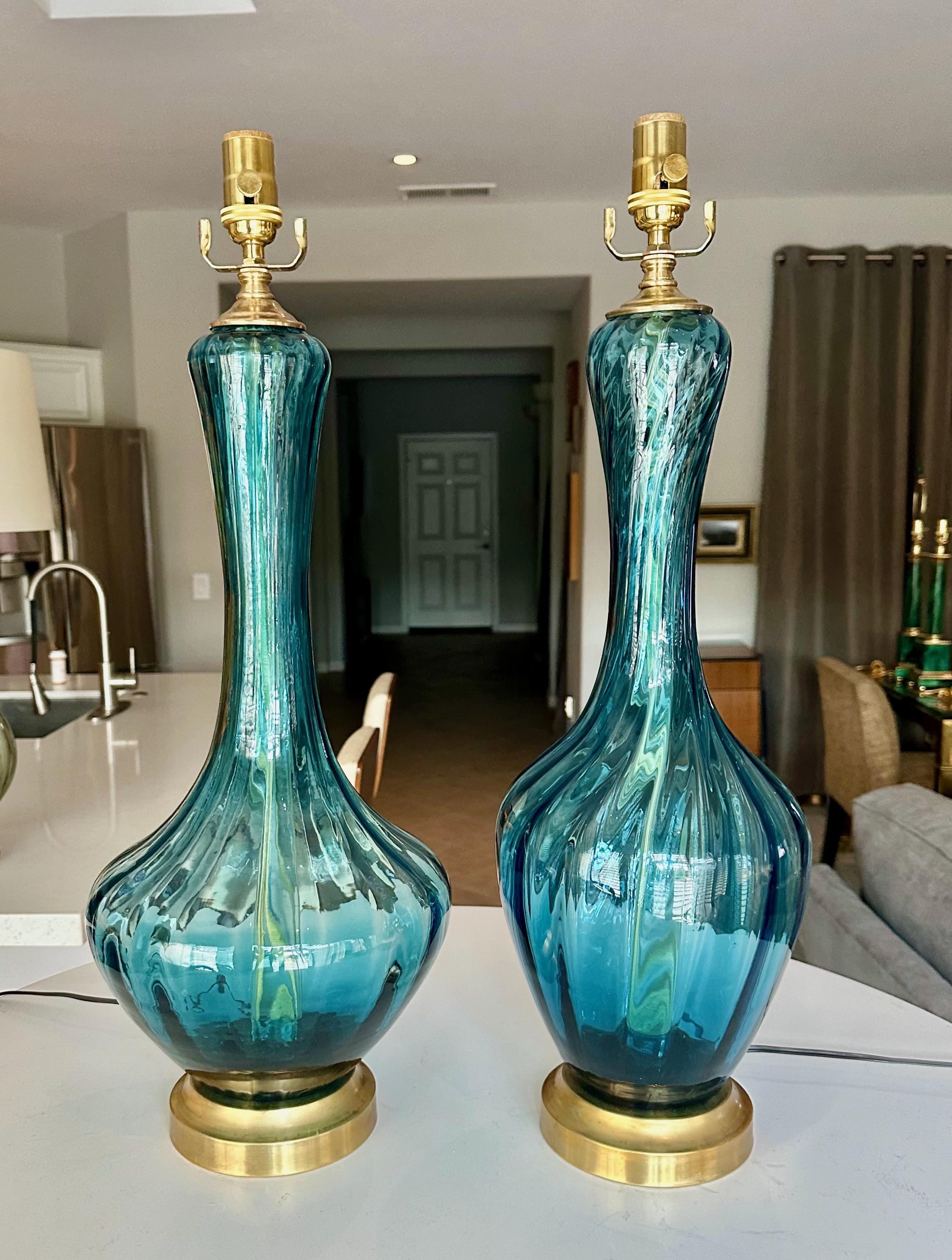 Pair of similar size and shape Empoli Venetian optic glass table lamps in a vibrant blue. Mounted on brass bases, with brass fittings and new 3 way socket and cords. Newly wired for US. Sold as a pair only. 

Each lamp is 26
