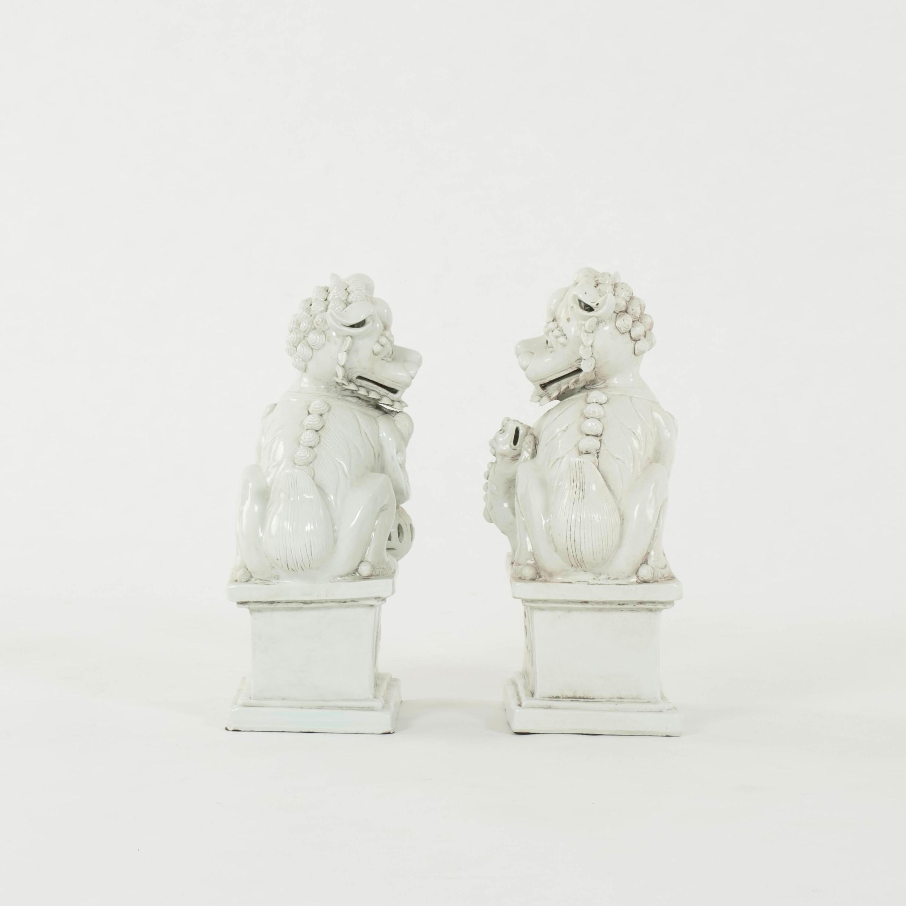 Pair of early 20th white porcelain fu dogs.