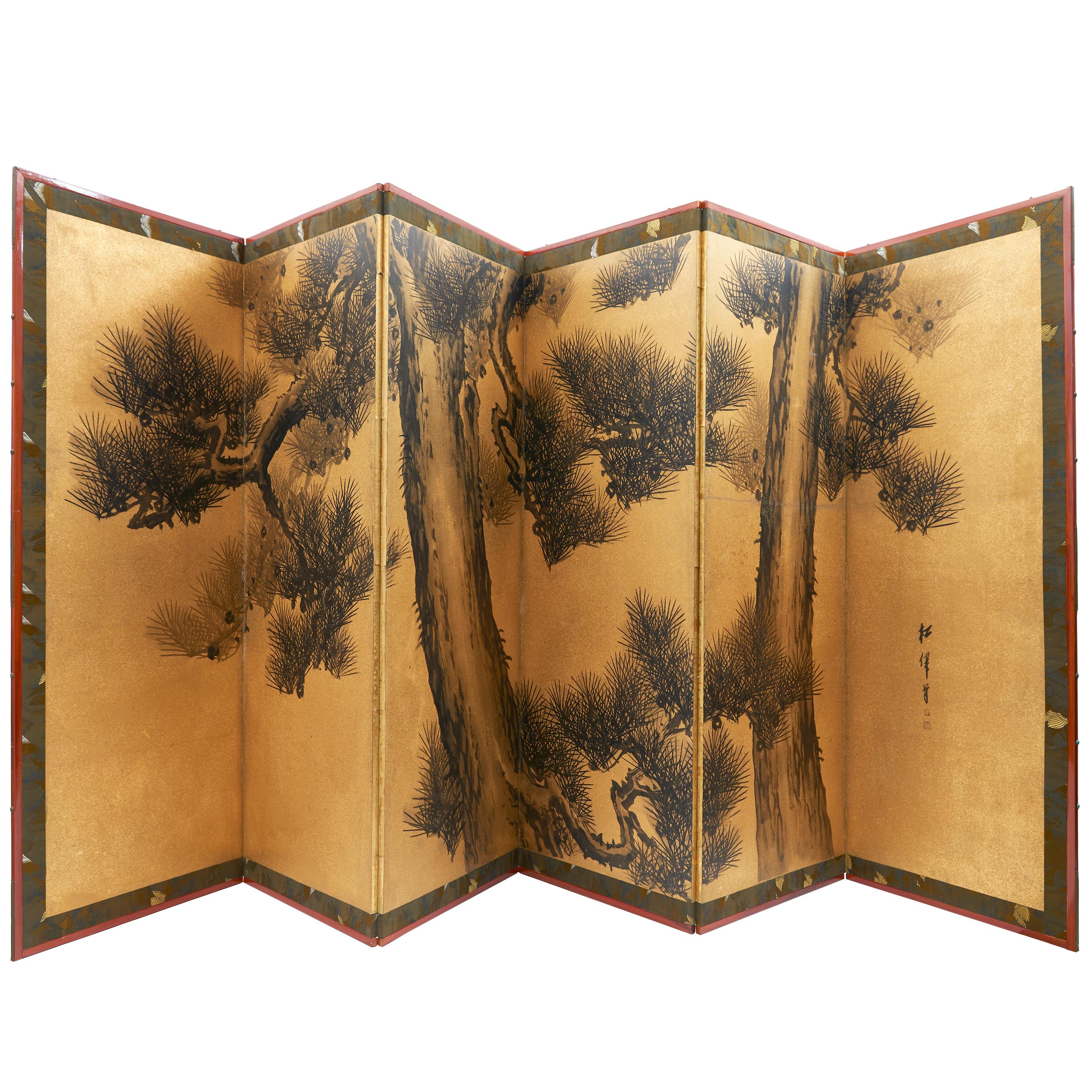 Pair of large six fold Japanese paper screens, both decorated with monochromatic pine trees on a gold ground. With a patterned silk border, early 20th century. All British and EU Sales are subject to VAT at 20%.