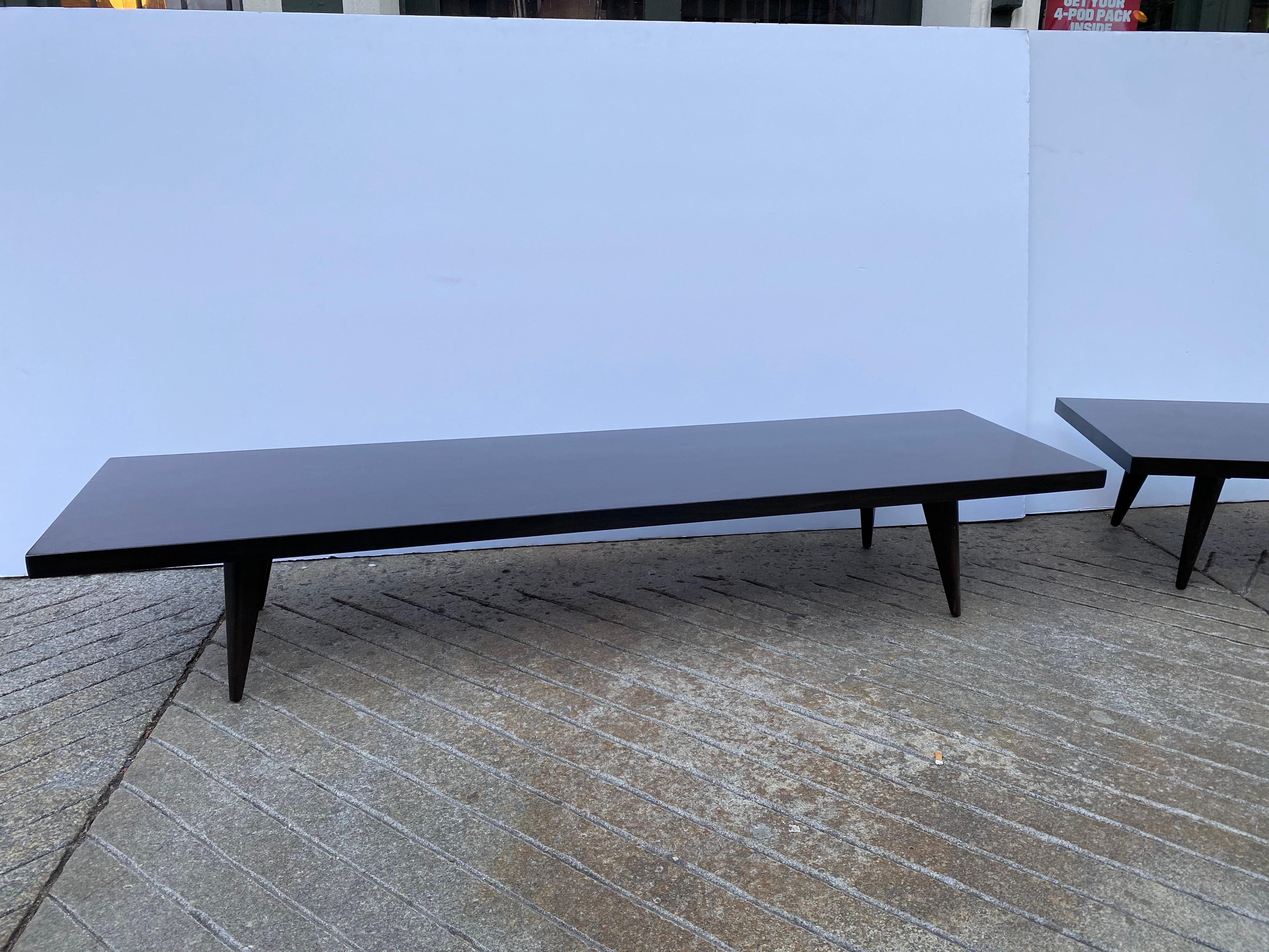 Pair of low sleek tables or benches. Measures: Large one: D: 20 W: 74 H: 12 smaller one: D: 20 W: 53 H:12. Perfect to use with low windows! Can be set up in a corner or used straight. Recently refinished in a dark walnut finish. Legs splay out at a