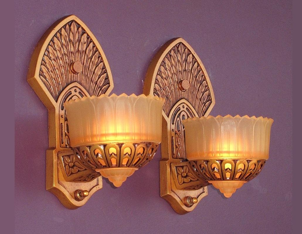 Gorgeous 1920s slip shade wall sconces with designs from Indigenous North Americans highlighting their artistic features of their day. Headdress feathers fan above the shade and behind the shade is a design from the northwest coastal