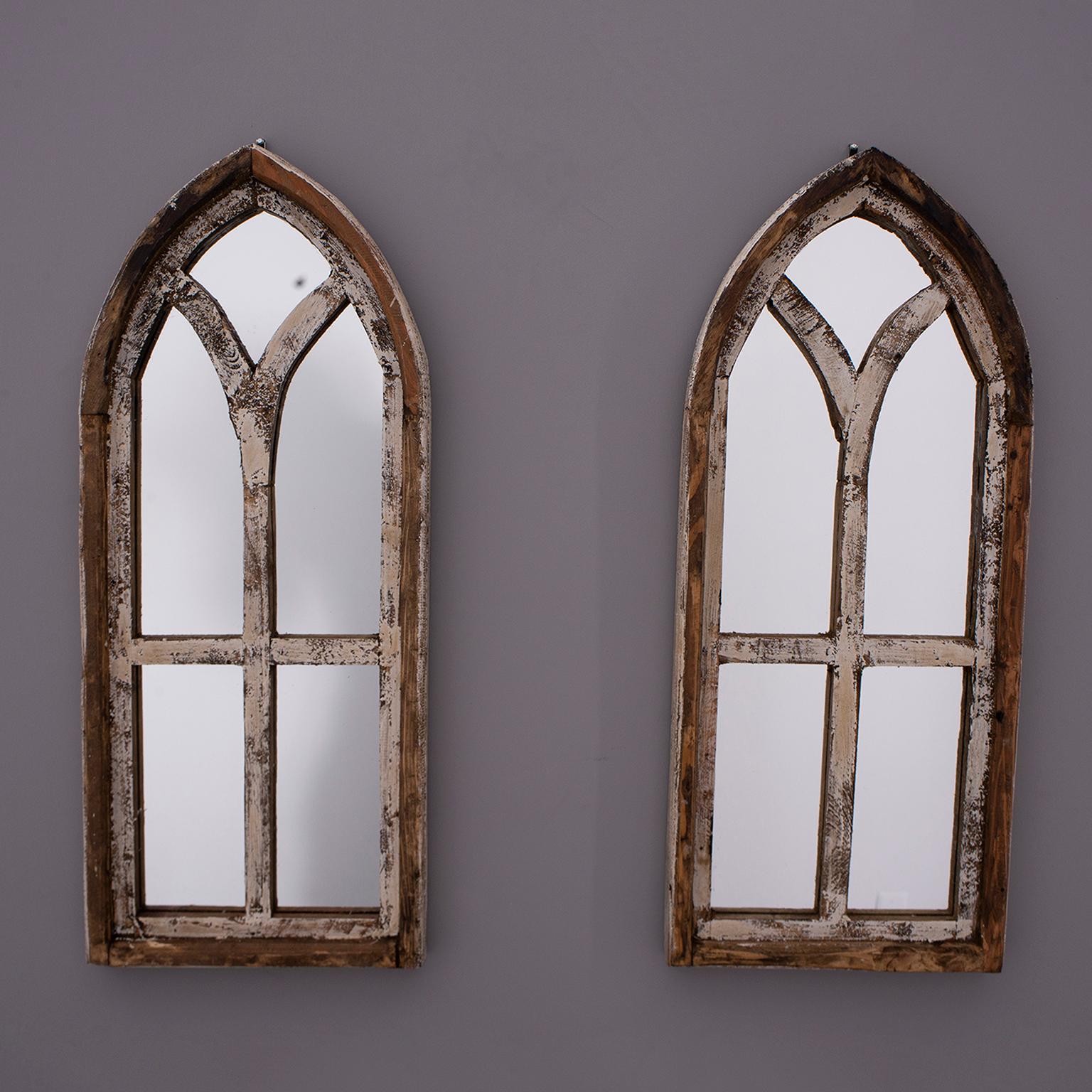 Pair small arched wooden window frames with original distressed creamy white paint. We had mirrors custom cut and glued into frames. Unknown origin and age. Sold and priced as a pair. 