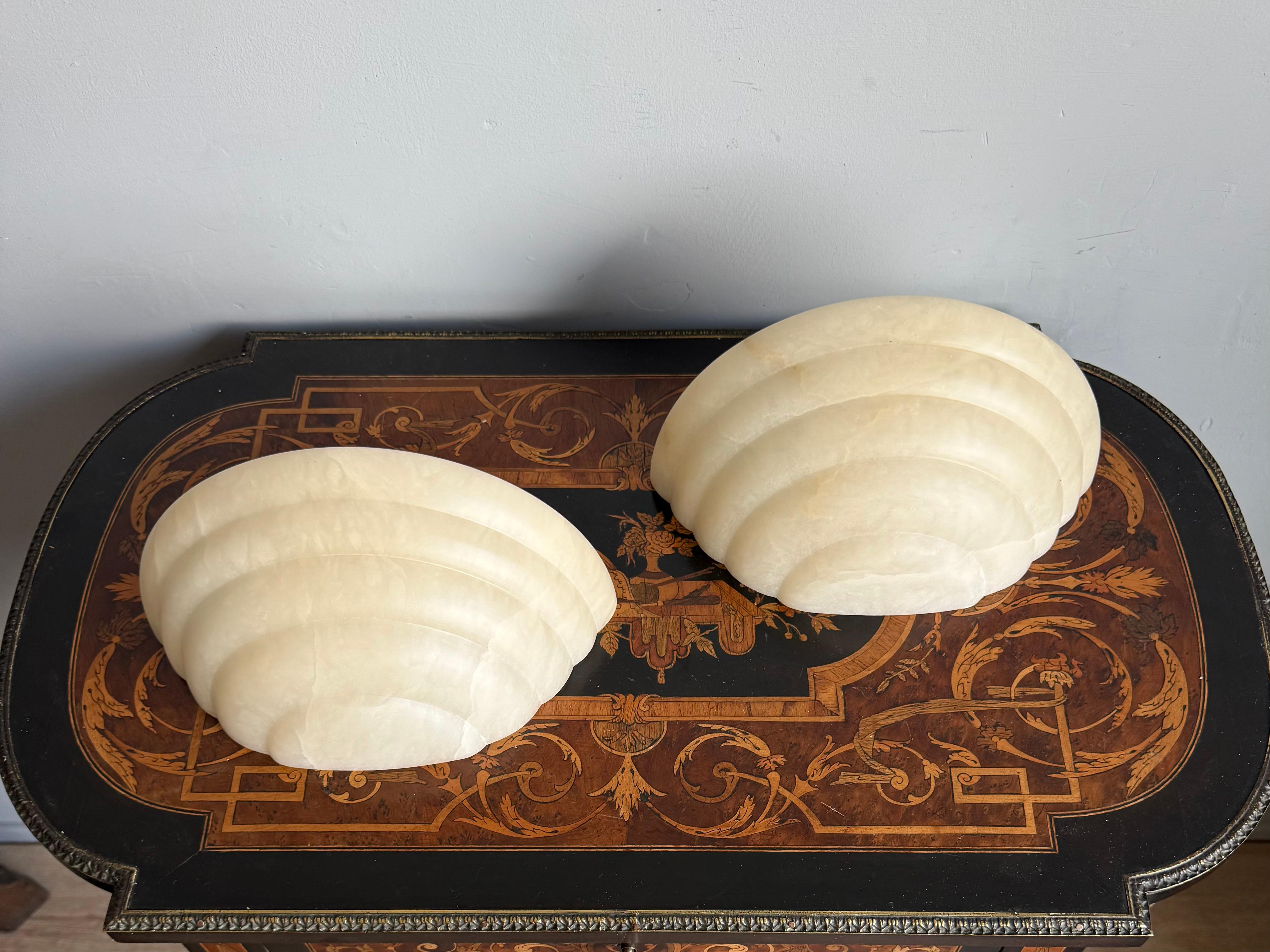MidCentury Era Mint Pair of Art Deco Style White Alabaster Wall Sconces / Lights

Elevate your interior with this stunning pair of sculptural layered alabaster wall sconces, handcrafted in the Art Deco style and dating to the 1970s. These