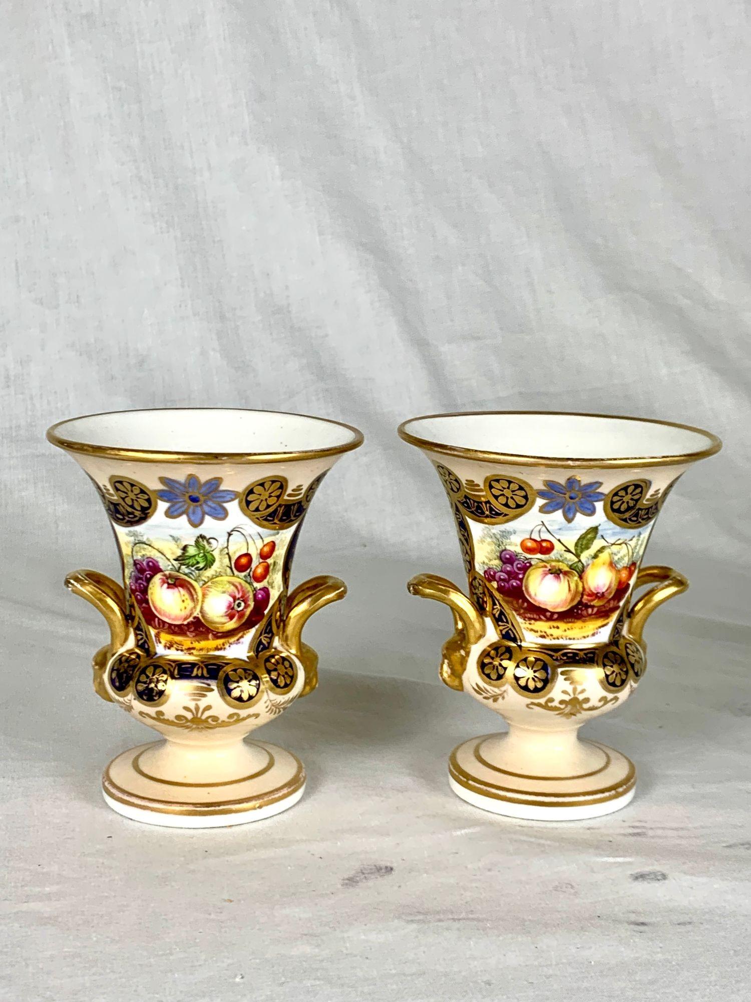 Dieses Paar englischer Porzellanvasen, handbemalt um 1840, zeigt den Charme und die Raffinesse dekorativer Waren aus der Mitte des 19. Jahrhunderts, bei denen ornamentale Brillanz und praktische Form mit müheloser Zuversicht zusammenkamen.
Jede Vase