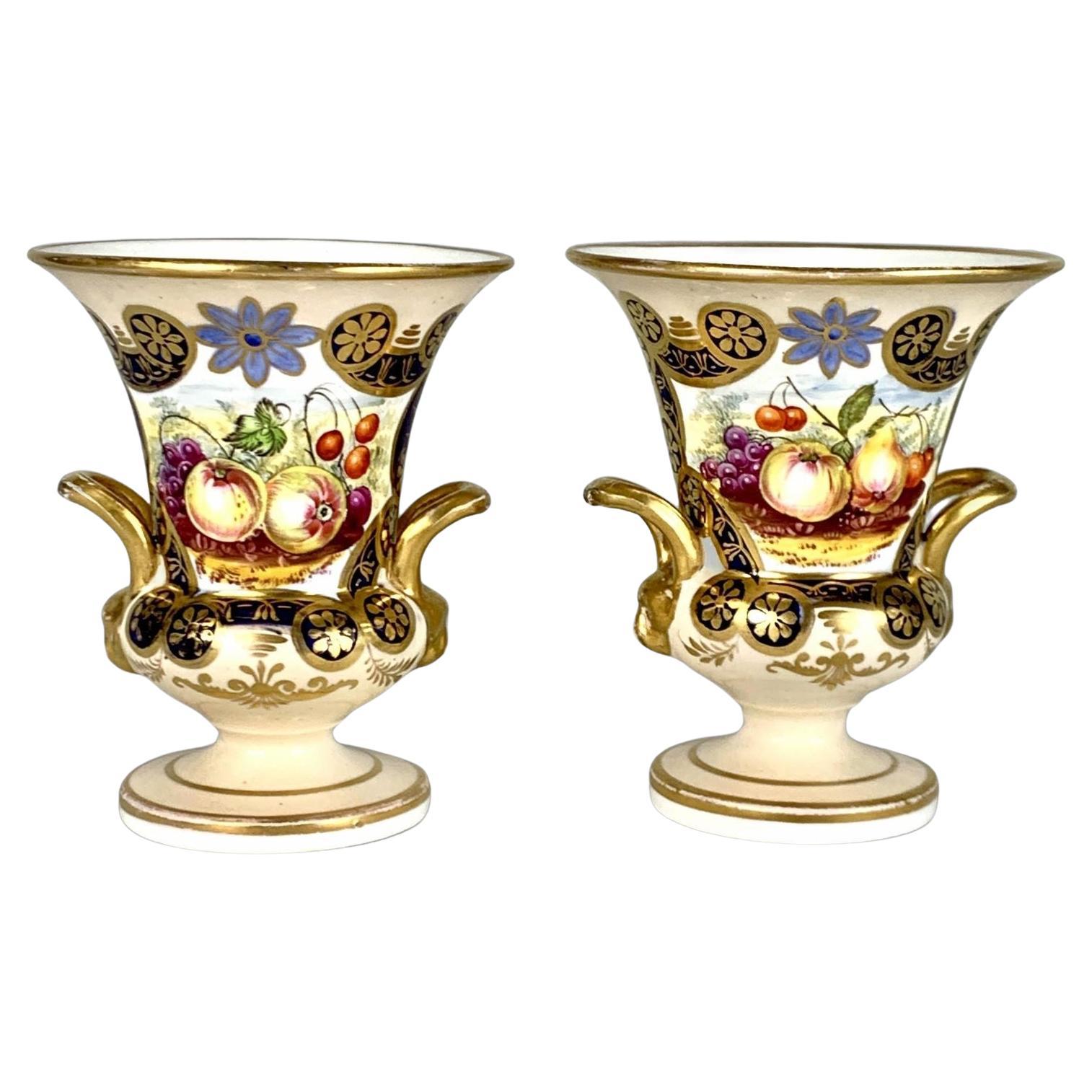 Coppia di piccoli vasi inglesi in porcellana dipinti a mano con frutta e decorazioni dorate