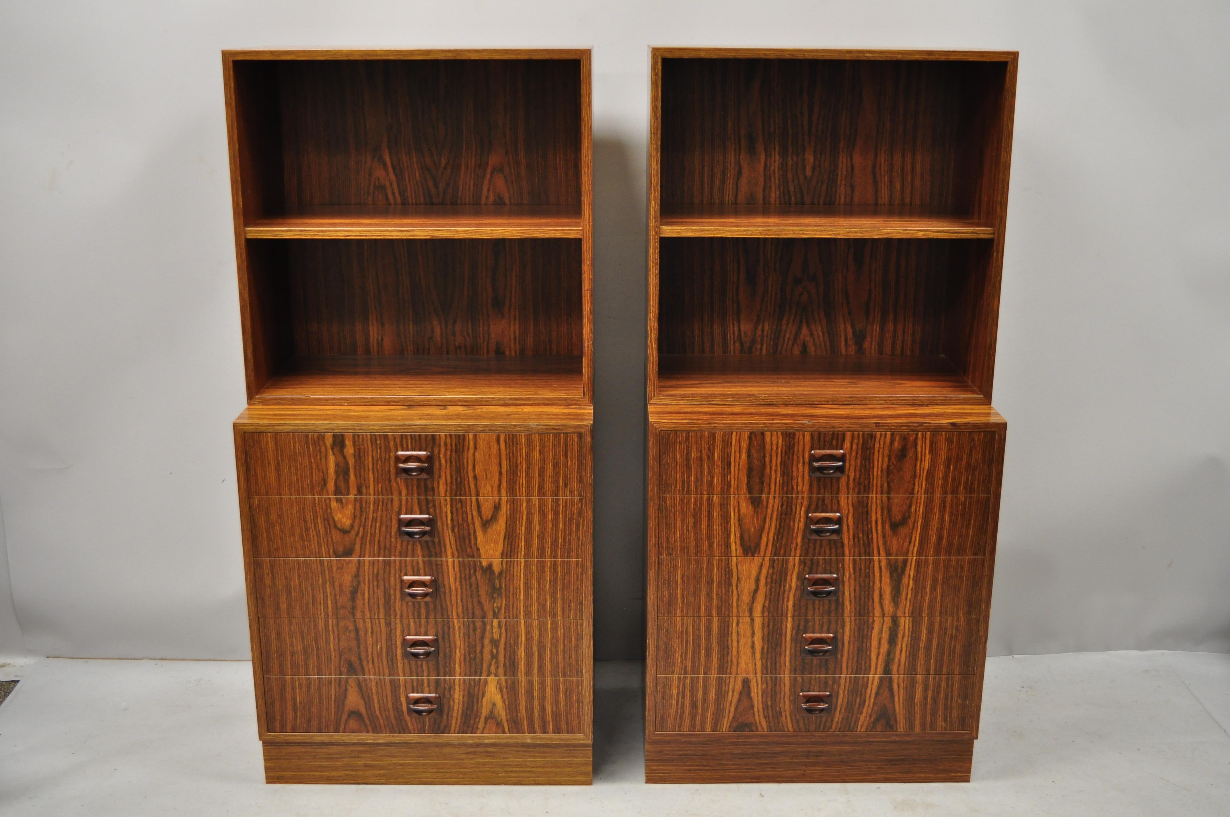 Pair of small midcentury Danish modern rosewood modular bookcase chest display shelves. Item features a nice small size, sculpted rosewood pulls, beautiful wood grain, 5 drawers, 1 adjustable shelf, clean modernist lines, great style and form, circa