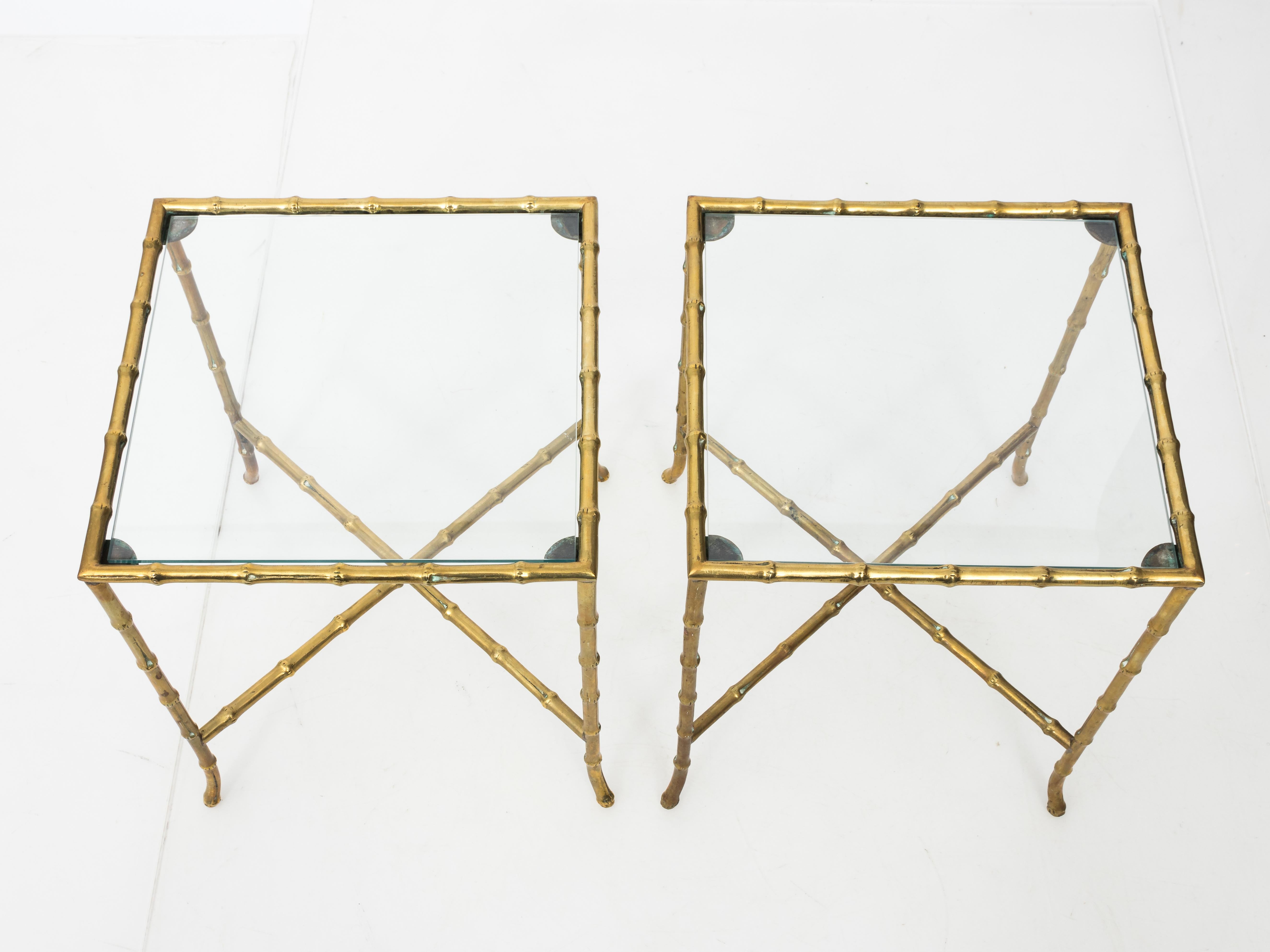 Pair of heavy solid brass faux bamboo side tables with square glass tops and turned out feet in the manner of Baguès. French, circa 1960. New glass tops.