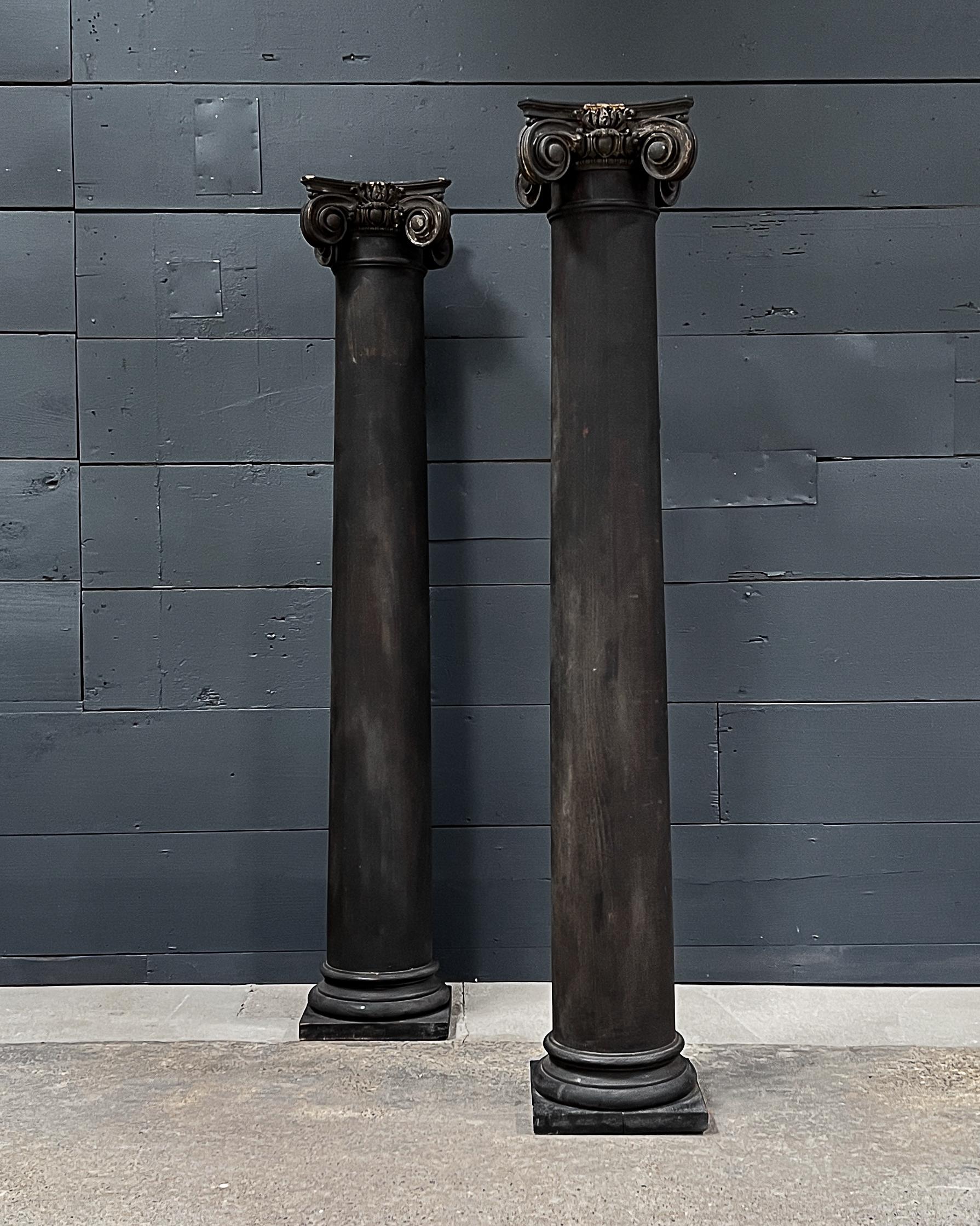 Wonderful old ionic columns salvaged from an old stately home in Nebraska. The ebonized columns are constructed from solid wood and are showing signs of craquelure, and great patina! Their streamlined dignified form, topped with scroll-shaped