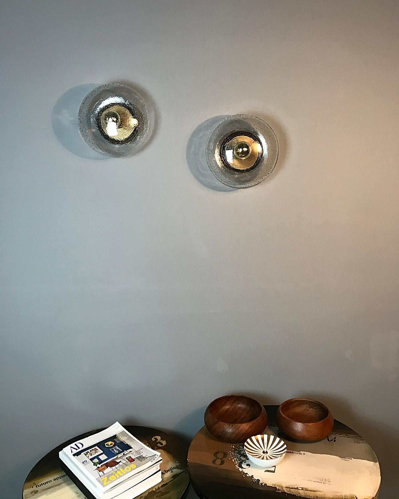Pair of beautiful wall or ceiling lamps manufactured by Hillebrand in 1970s. They are featuring a brushed brass reflective base with a hand blown glass shade.
Fully working and tested condition with one E27 Edison socket each, the lamps work on