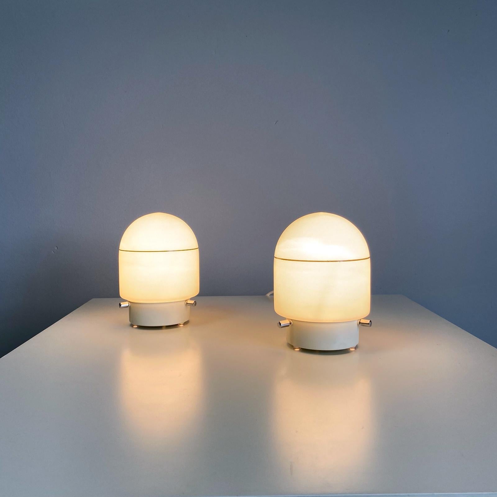 Pair of petite space age nightstand or table lamps manufactured by Peill & Putzler in Germany. The lamps are made of blown white opal glass - the lamps provide smooth and wonderful light. The lamps are in very good condition. Fully working rewired