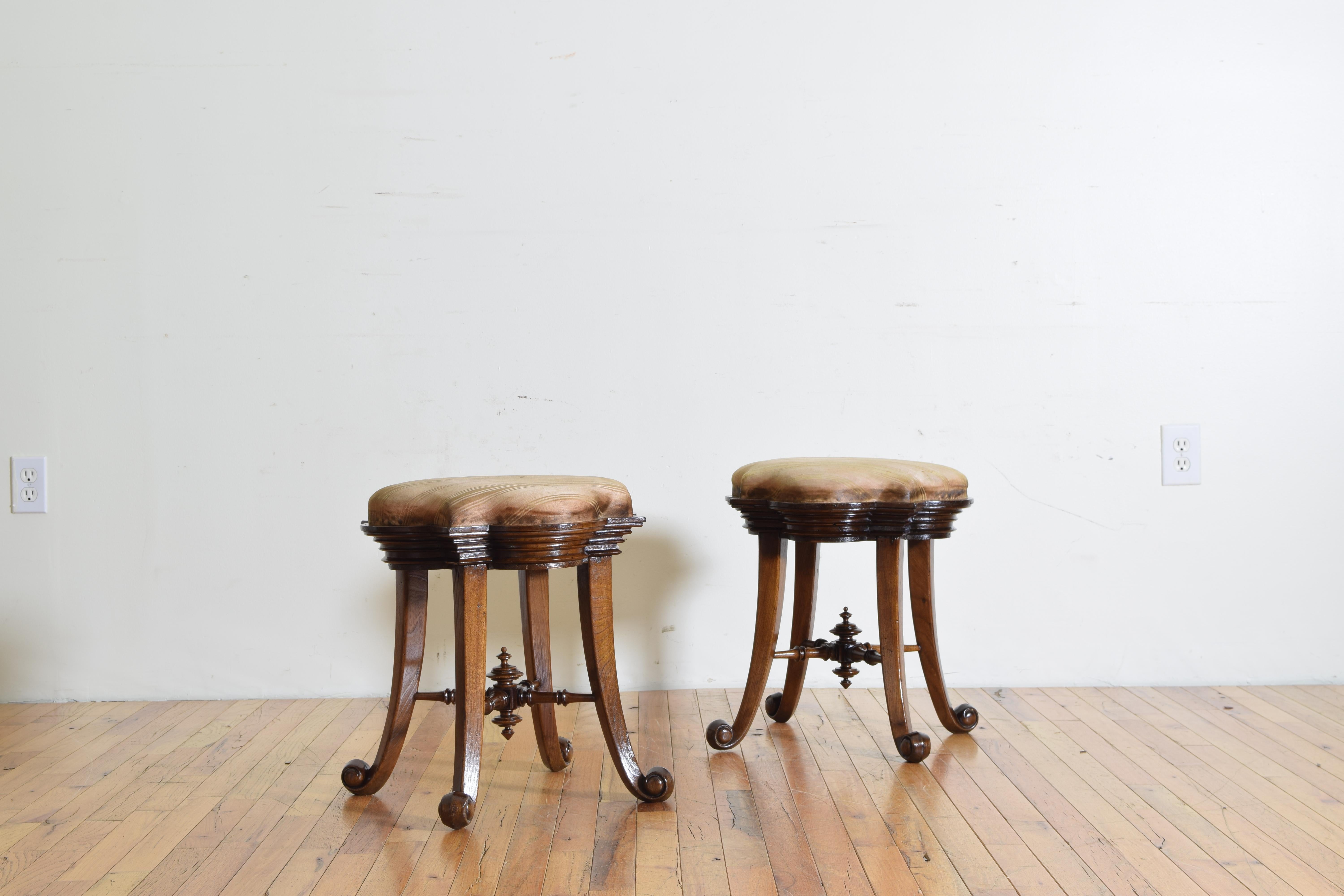 Each having a quatrefoil shaped inset top within a frame with a vertically graduated molded edge, raised on shaped splayed legs ending in scrolled feet, joined by turned X-form stretchers with ball turned centers, second quarter of the 20th century.