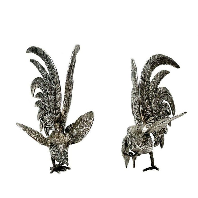 Pair Spanish solid silver fighting cocks roosters figures 2nd quarter, 20th century.

Pair Spanish solid silver fighting cocks figures, possibly 2nd quarter 20th century. Impressed pentagon cartouche to wing, purity likely either 750 or 800