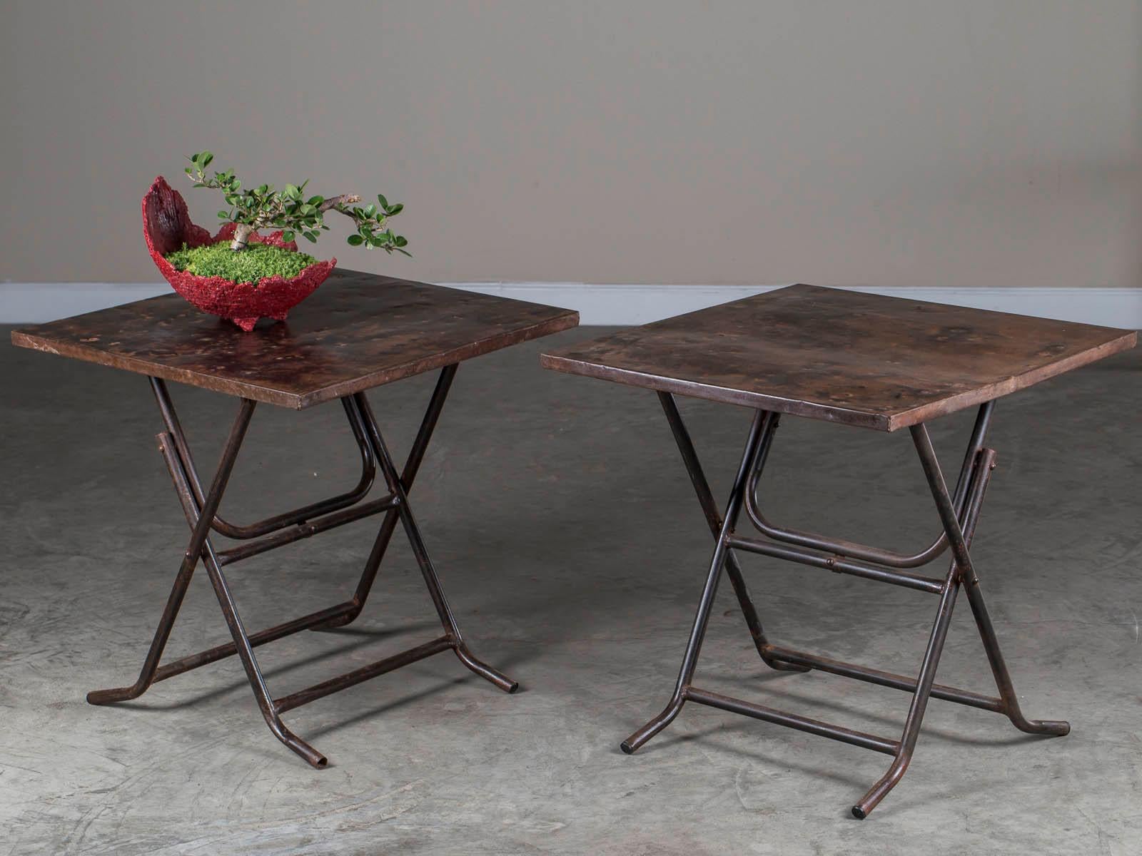 A super functional and good looking pair of square metal folding tables with folded edges and tubular legs found in Asia. The scale of these tables are perfect for bedside or sofa as they easily accommodate a lamp and objects across their surface.