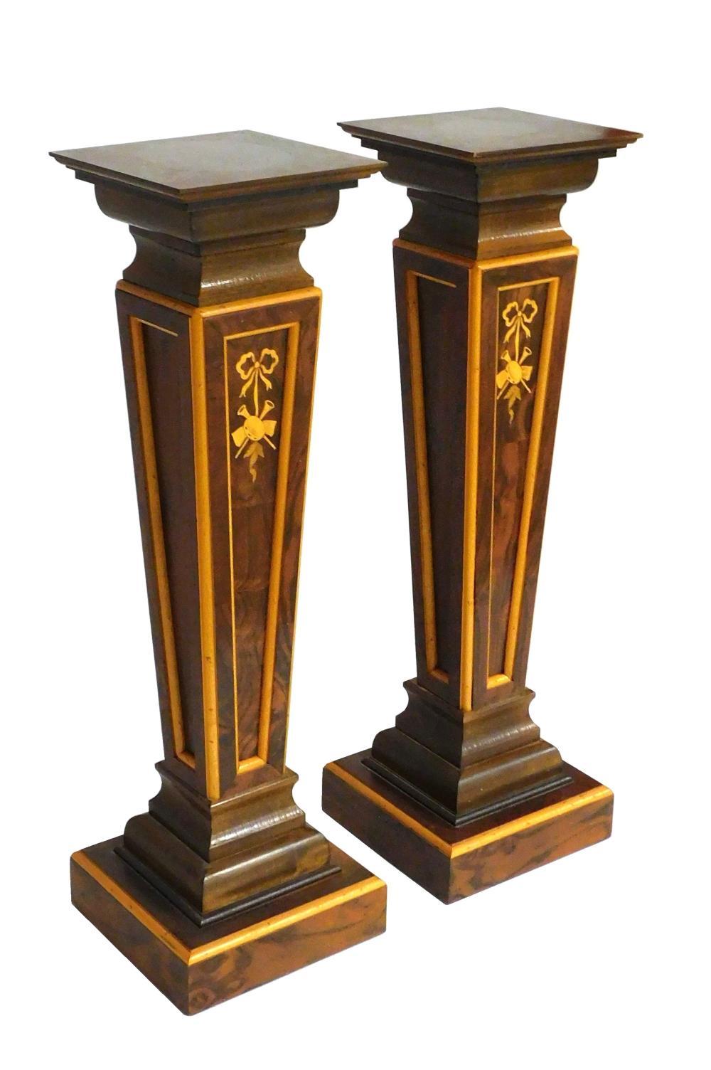 Elevate your space with this stunning Pair of Continental Inlaid Display Pedestals, crafted in the mid-20th century. Each pedestal features a square top adorned with exquisite burl wood, adding richness and depth to its appearance. The elegant
