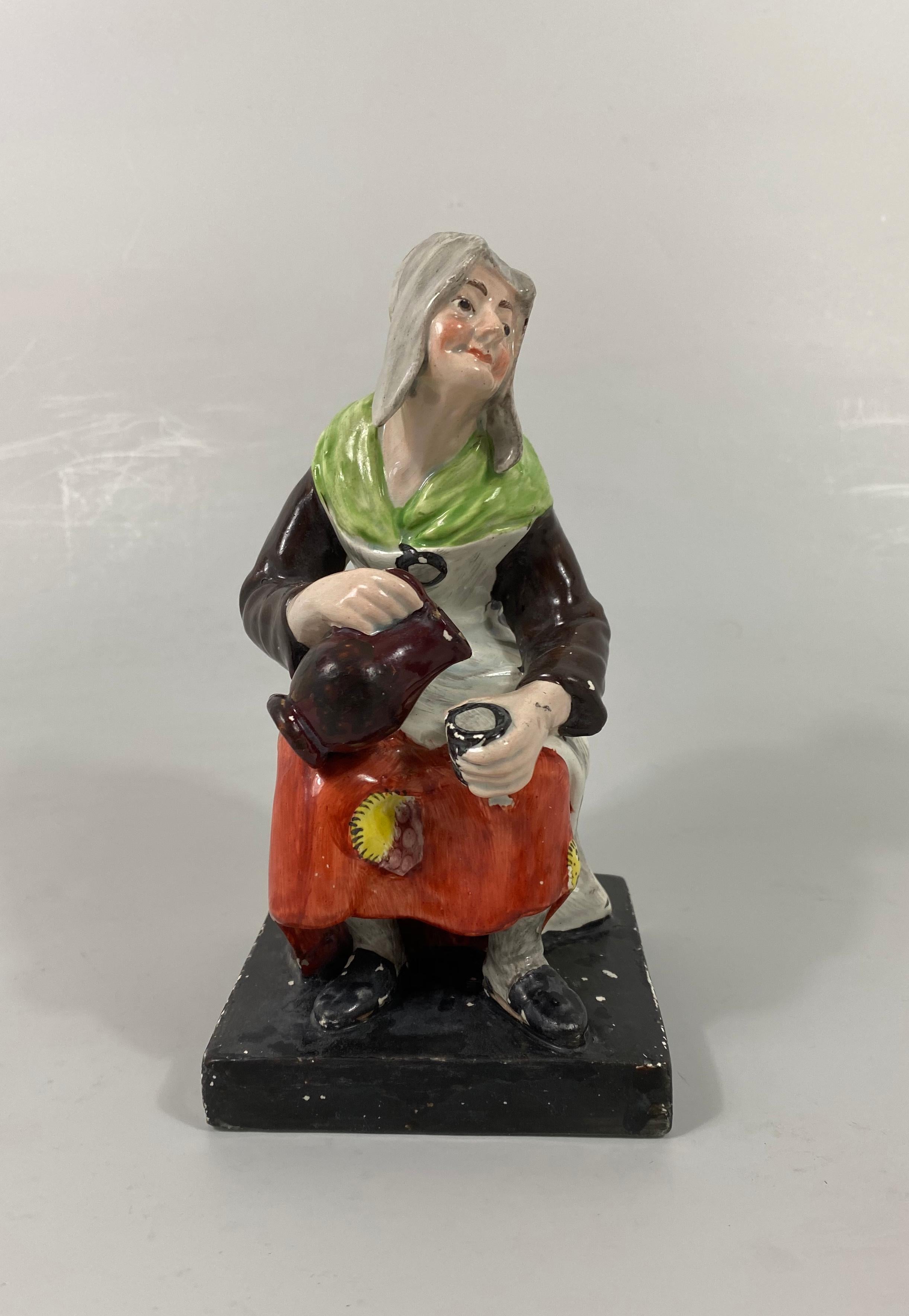 Pair of Staffordshire pottery figures, probably Enoch Wood factory, circa 1820. The figures very well modelled as ‘Jobson and Nell’. The seated cobbler repairing a shoe, with a dog beneath his stool. Whilst his wife Nell, pours drink into a cup,