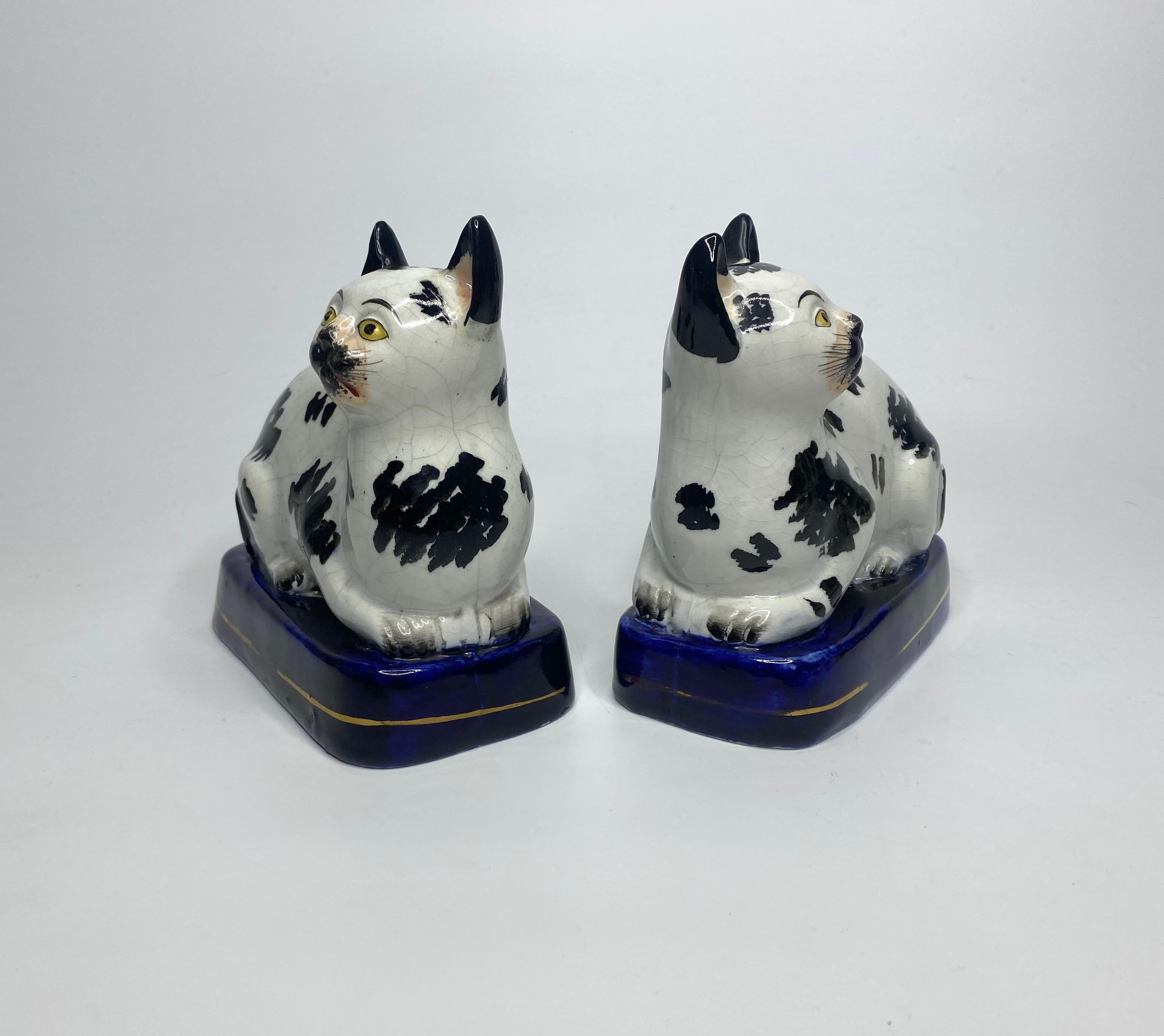 Rare and fine pair of Staffordshire pottery cats, c. 1850. The recumbent cats, painted with large underglaze black spots, and having yellow eyes. Set upon underglaze cobalt blue oval bases with a single gilt lines.
Height: 14 cm, 5 1/2”.
Width: 14.2