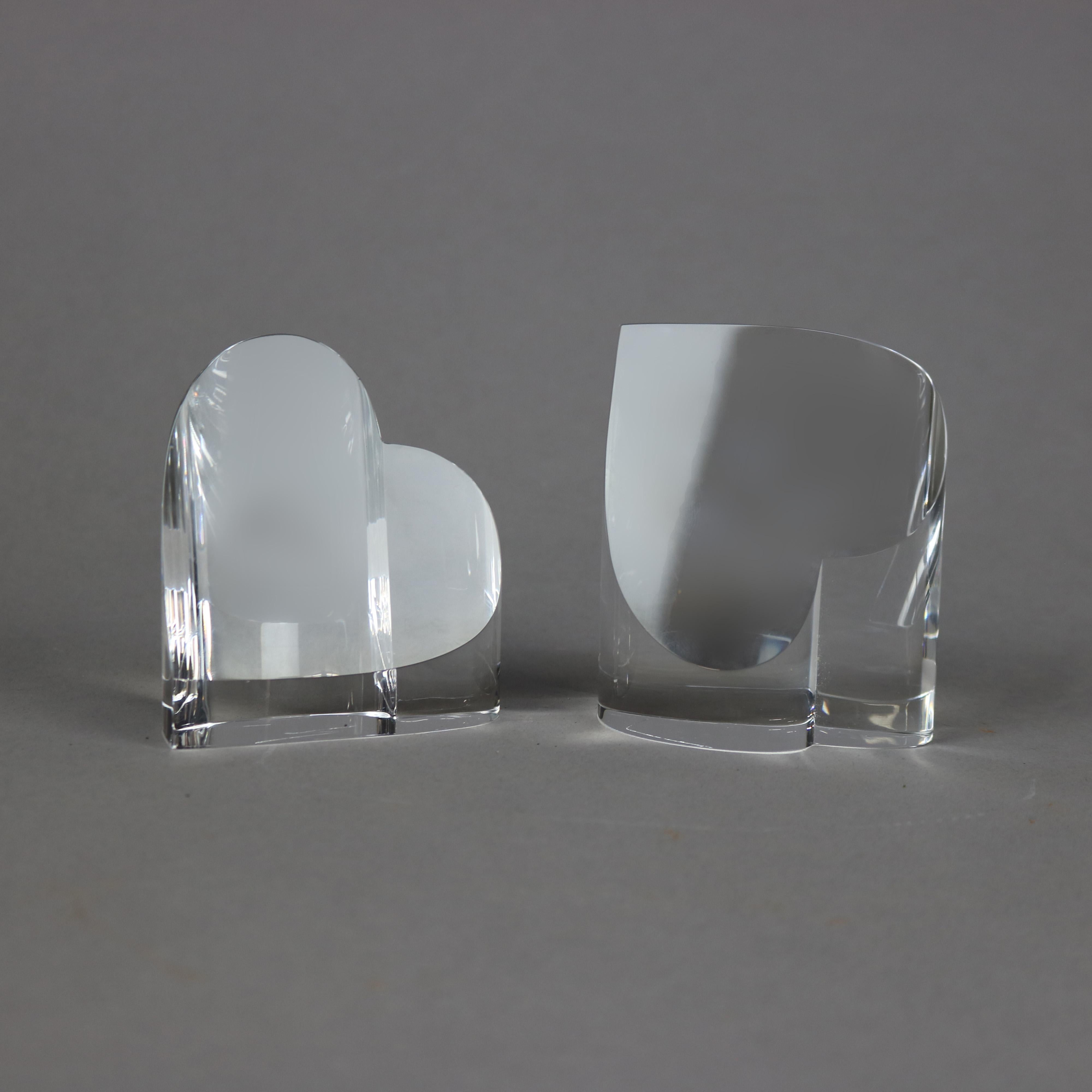 A pair of paperweights by Steuben offers colorless art glass hearts, signed, 20th century.

Measures- larger 3.75''H x 3.25''W x 1.5''D; smaller 3.5''H x 3.25''W x 1.5''D.
