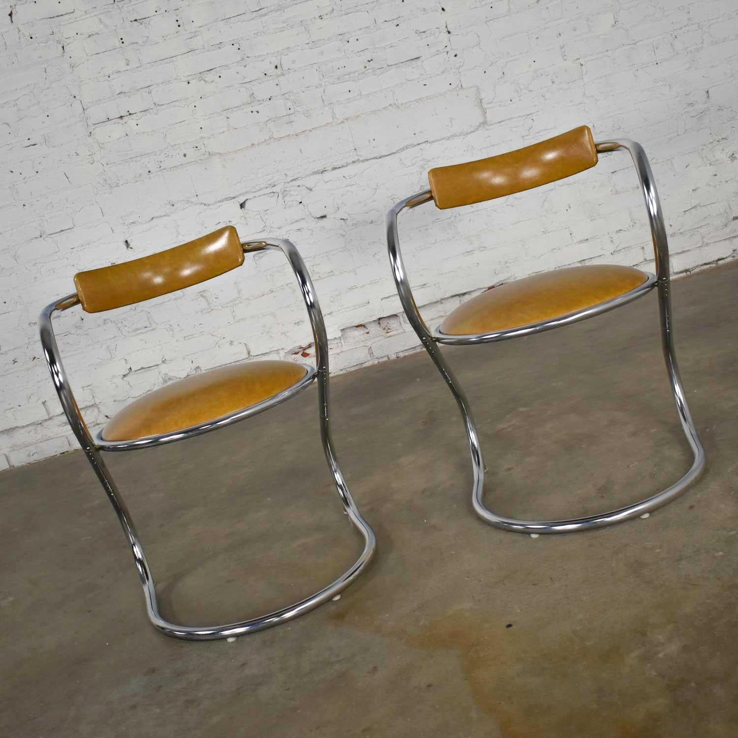 Handsome pair of streamlined reversed cantilever chairs comprised of chrome frames and gold faux leather or vinyl by Sutton Bridge, a division of Etowah Manufacturing Co. Inc. Beautiful condition with no outstanding flaws that we have detected. Only