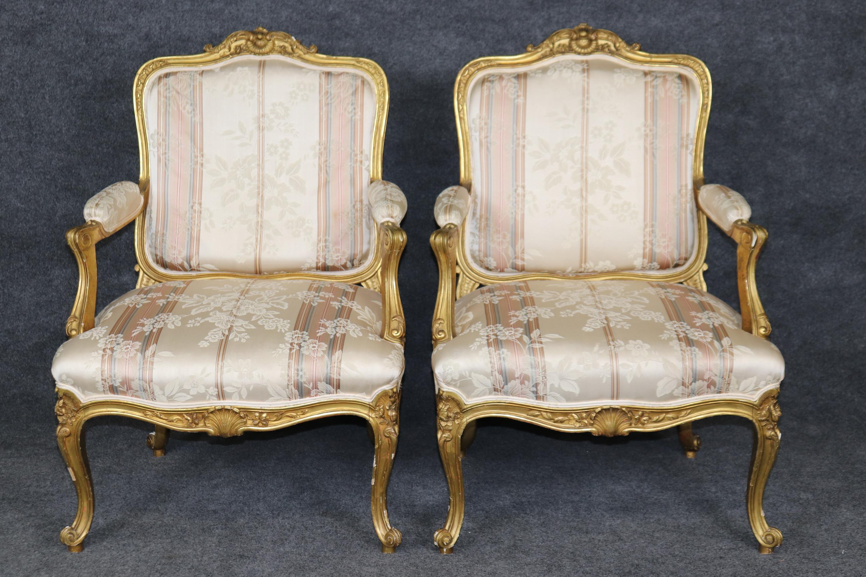 This is a gorgeous set of 1920s era French made louis xv gilded armchairs. The upholstery is in good conditon but is used so it may have signs fo age and use. The frames are in good condition with moderate signs of chips and surfaces scuffs to the