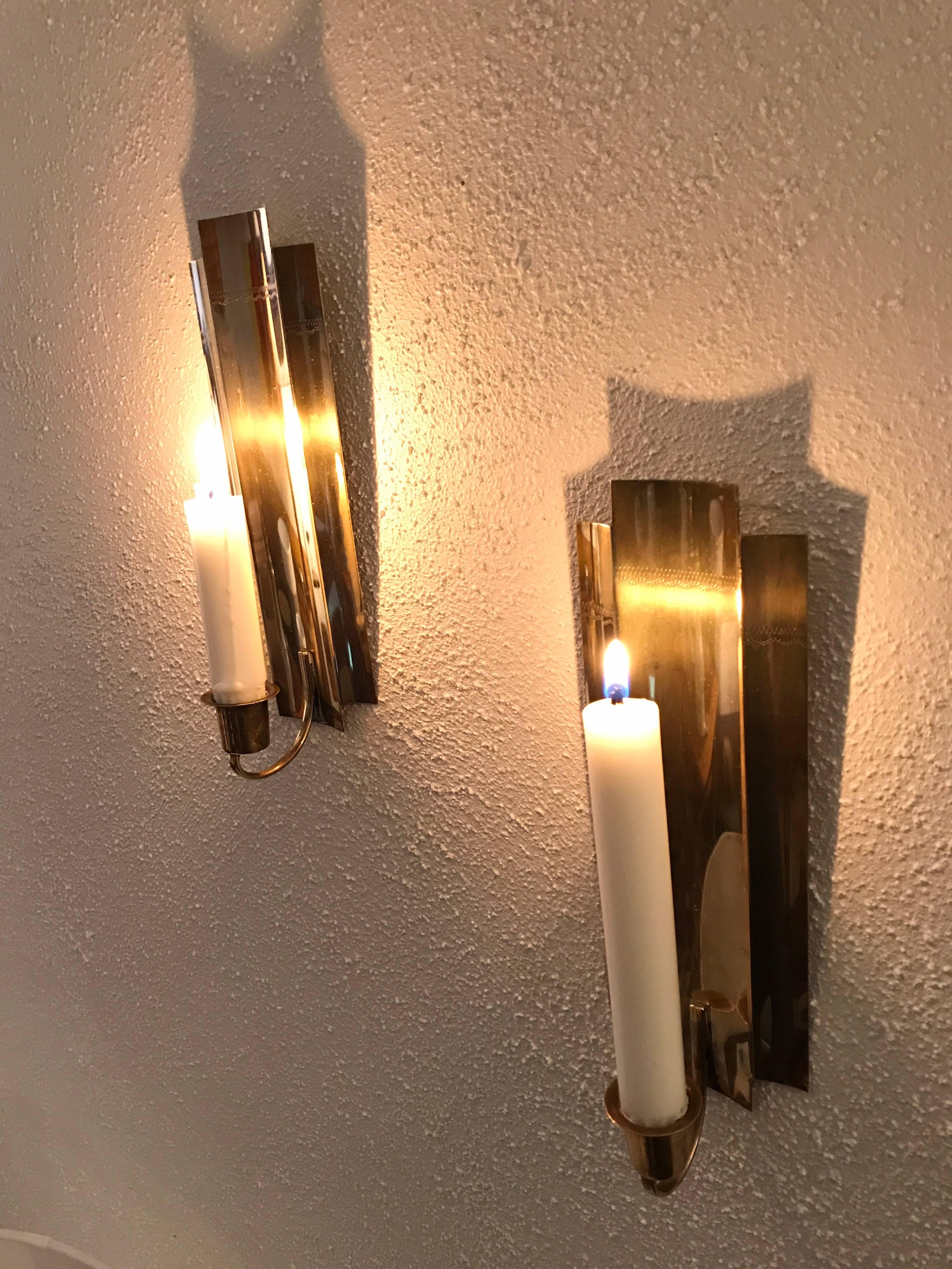 Pair of Swedish brass candle wall sconces 1950.
A nice pair of wall sconces for candles, the sconces are in a very nice condition without any damages. 
They measure 24.5 cm in height and 8cm wide. Maker is unknown.