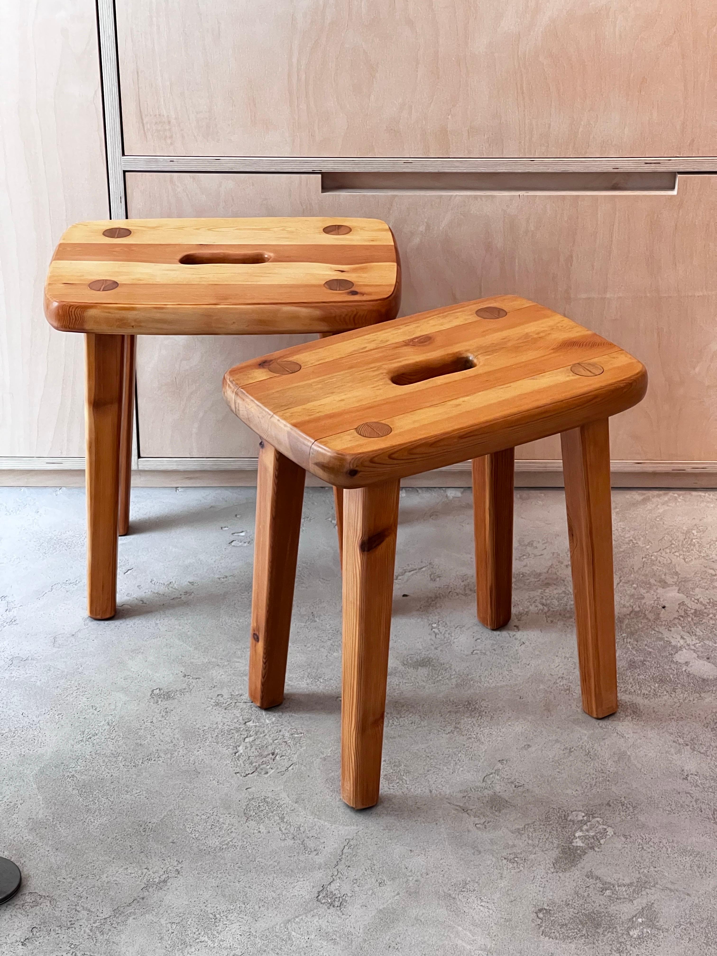 Handmade Swedish stools with massive slays of pine. It is a rectangular shaped with rounded edges. The joinery is really elegant. They were refinished and shows various shades of  honey tones. Elegant and brutalist describe those stools properly.