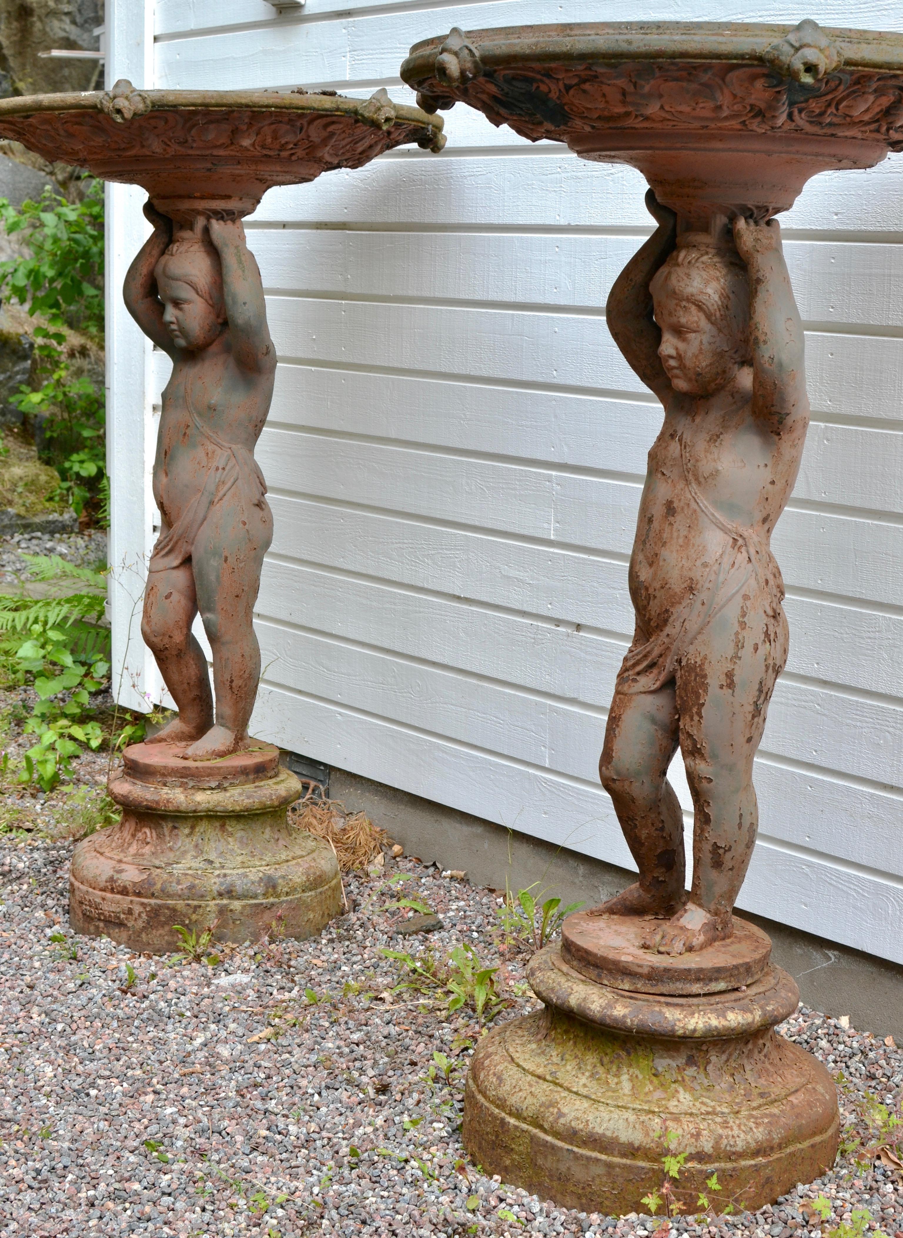 A large and rare pair of 19th century figural cast iron garden jardinières. Each with putti holding the jardinière above their heads. Both signed Bolinder, Stockholm. Made in the second half of the 19th century.

 Bolinder won a number of prizes