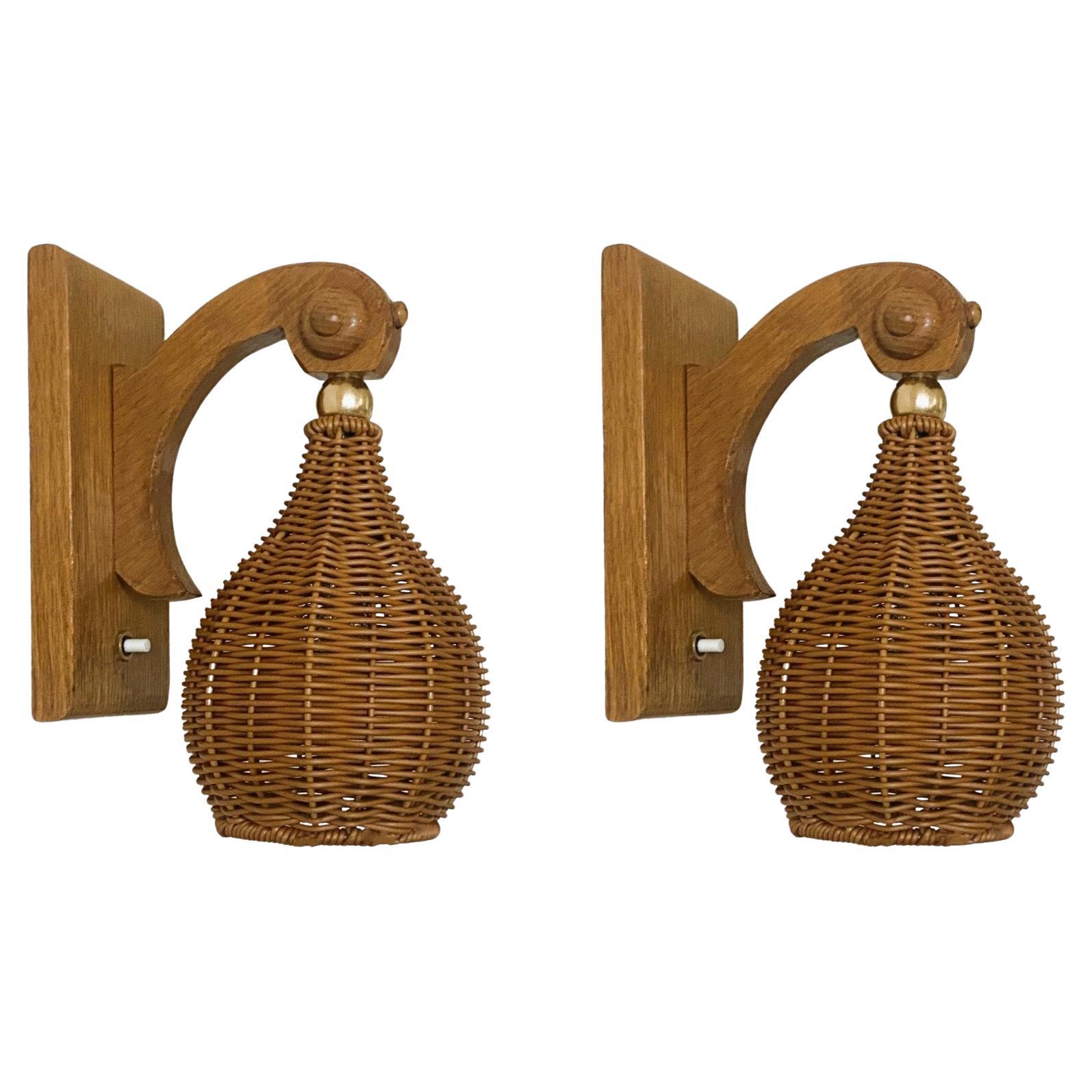A lovely pair of pine wood wall sconces with beautiful hand-made wicker lampshades from Sweden in the 1960s. Clean lines and  design from the Scandinavian Modern period. Both sconces in good vintage condition, original lampshades, no damages, fully