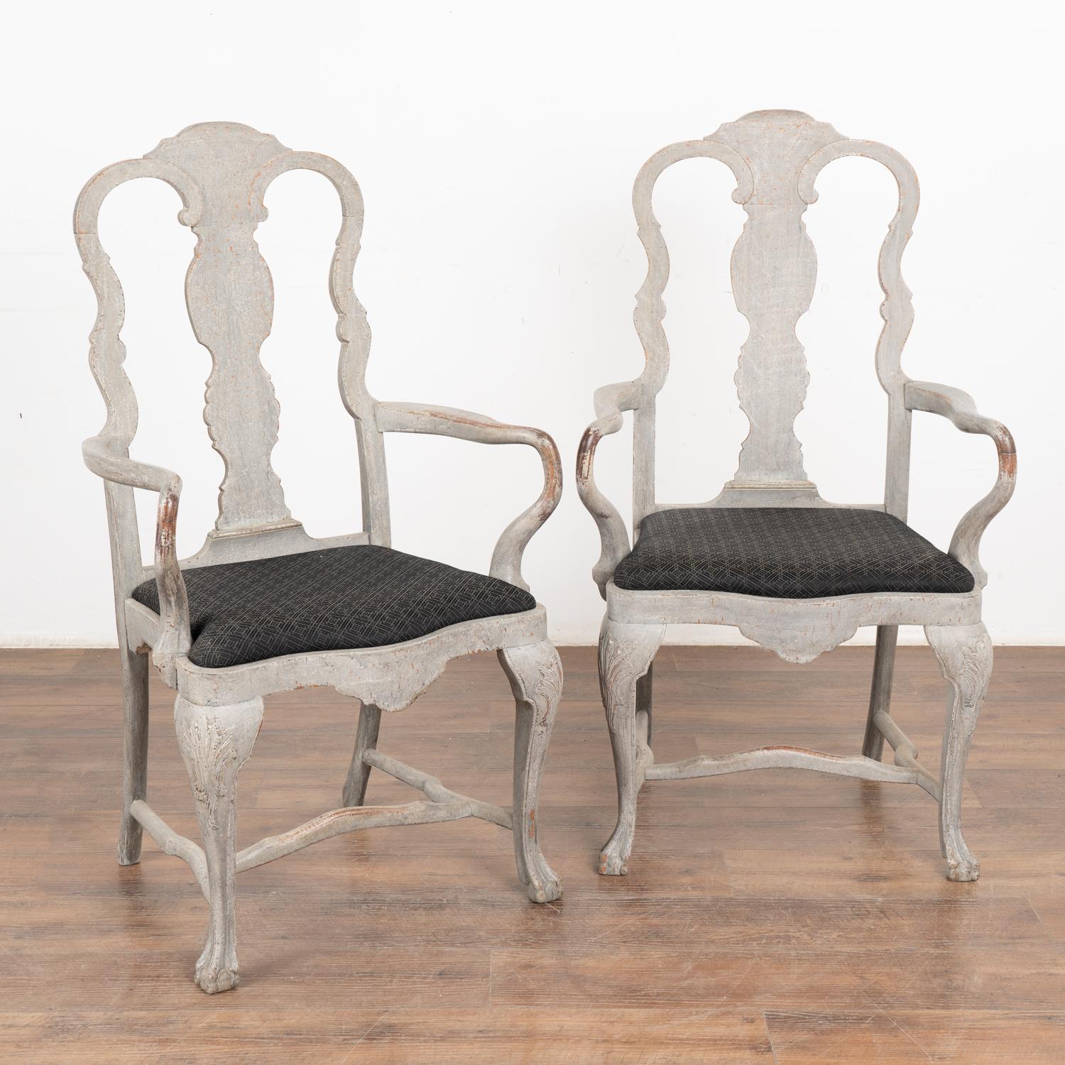 Ricca di curve e linee aggraziate, questa coppia di poltrone svedesi in stile rococò ha una finitura verniciata in grigio tenue.
La finitura verniciata in grigio tortora è afflitta da una serie di macchie, in particolare intorno ai braccioli.
I