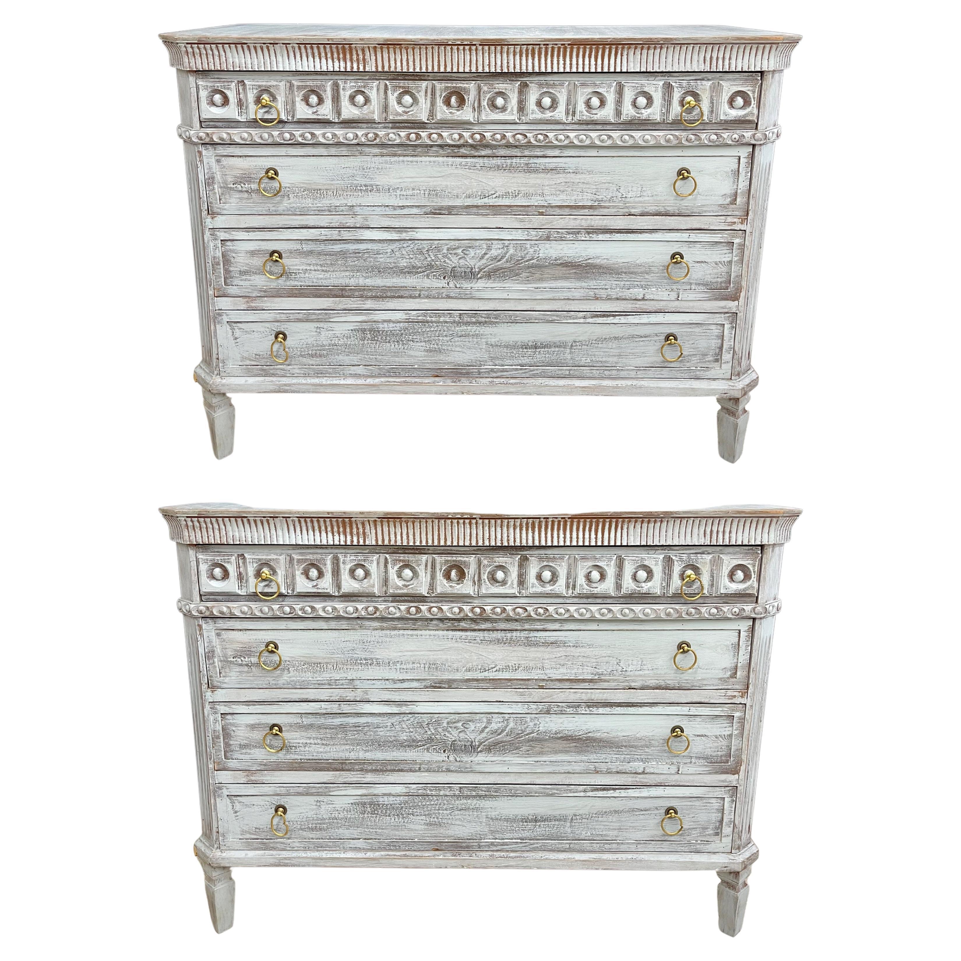 Pair of Swedish style three-drawer commodes or nightstands each on square tapering legs with brass drawer pulls. Having dental molding style carvings. Lovely tan with gray distress paint.