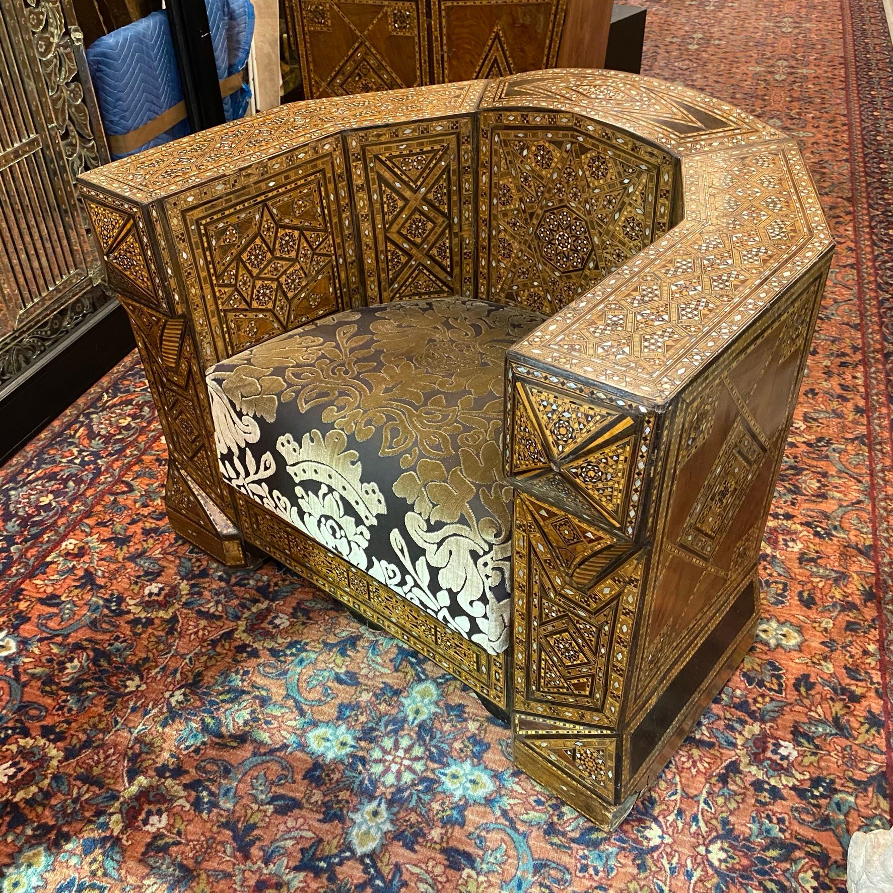 Our pair of antique middle eastern armchairs with exceptional inlaid parquetry of alternative woods and mother of pearl measure 30.5 by 36.25 by 29 in (77.5 by 92 by 74 cm). Each with modern upholstery in good condition, but with some discoloration