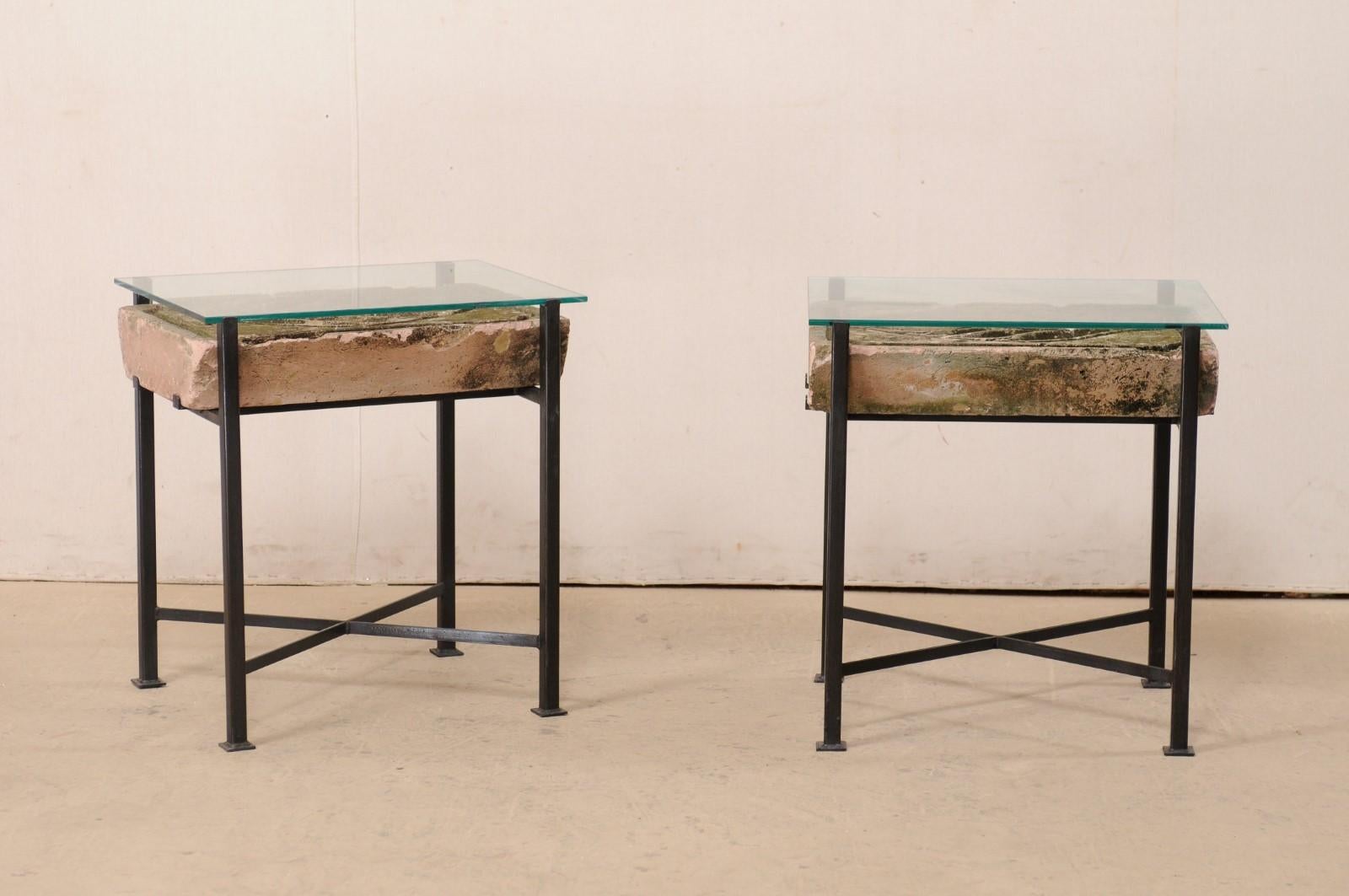 This is a custom pair of side tables, with an thick-cut section of French carved-stone from the early 20th century, on new iron bases. These unique side tables have been fashioned from an antique stone slab, with a single large-sized leaf carved