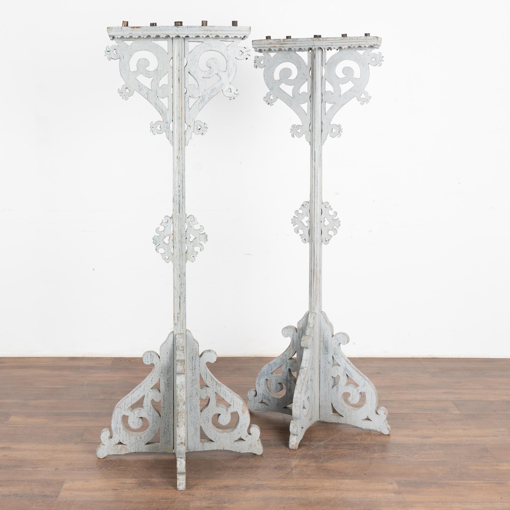 Paire de bougeoirs inhabituels et décoratifs d'une hauteur de 5,5 pieds. Le treillis sculpté, les volutes et la base se combinent dans cette paire autonome.
Chacune contient cinq bougies, la centrale étant légèrement plus grande que les quatre