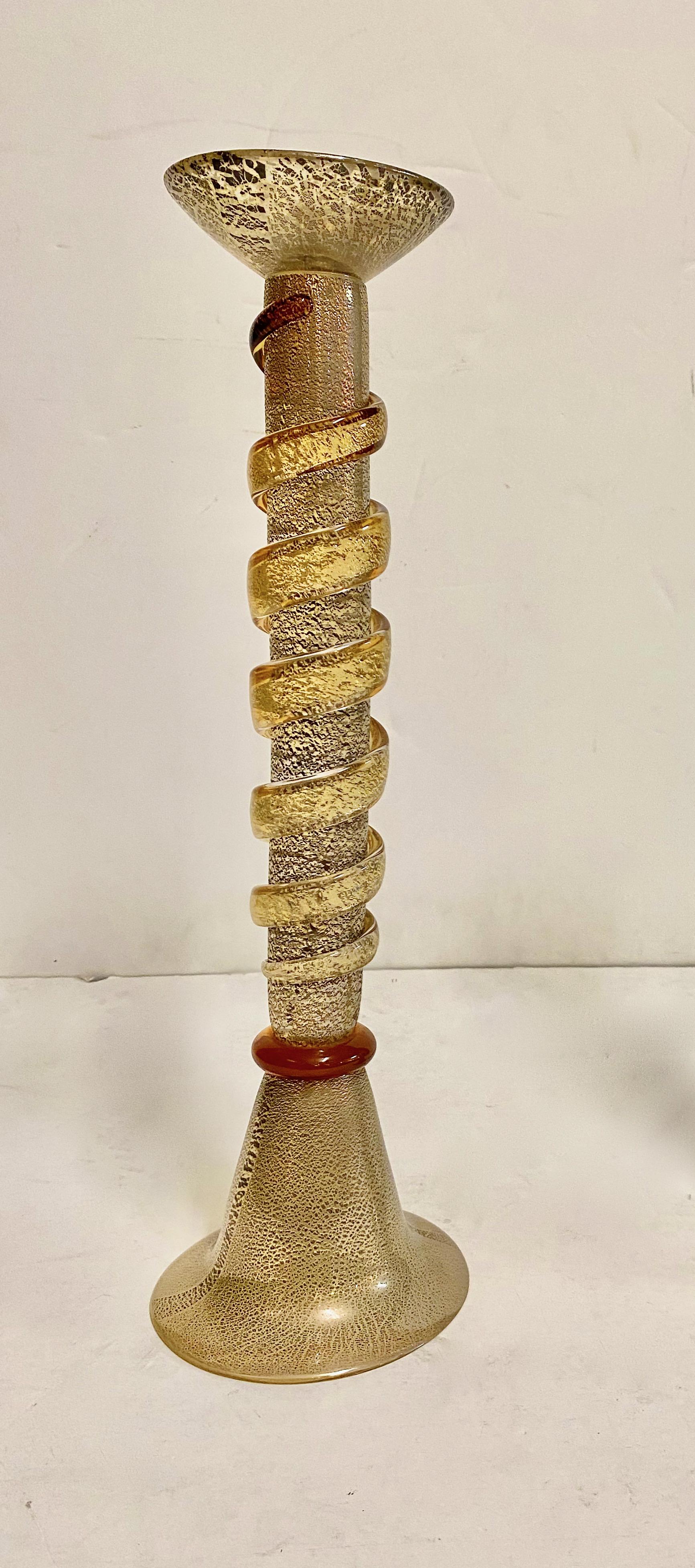 This is a stunning large pair of Murano candlesticks in the style of Memphis Milano, a design group founded and headed by Ettore Sottsass that was active between 1980 and 1987. The whimsical form of the tall balusters entwined by an abstract