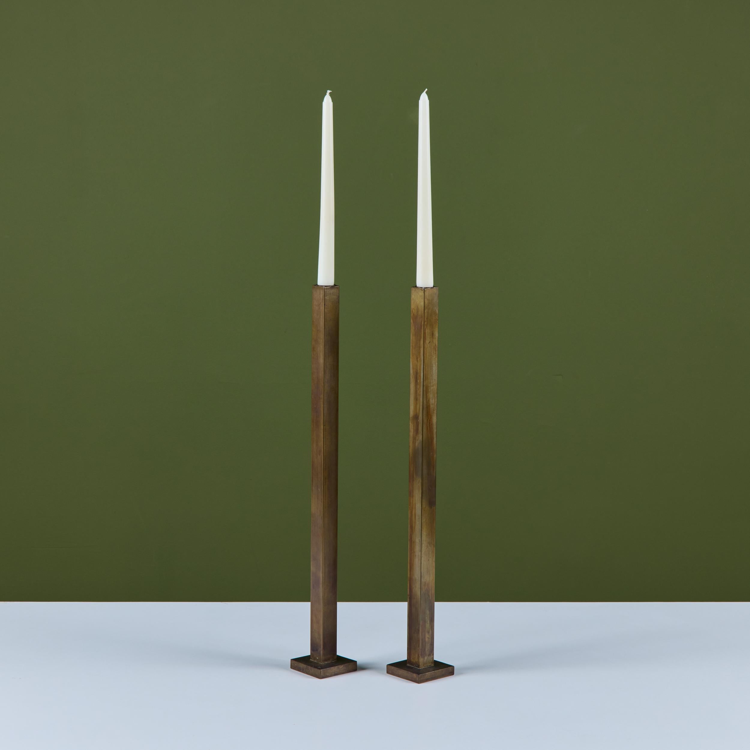 Pair of solid brass minimalist candlesticks by Canadian designer Martha Sturdy. The pair features a square tube stem on a square base. 
Labeled Martha Sturdy.

Dimensions
Each candlestick: 2.5