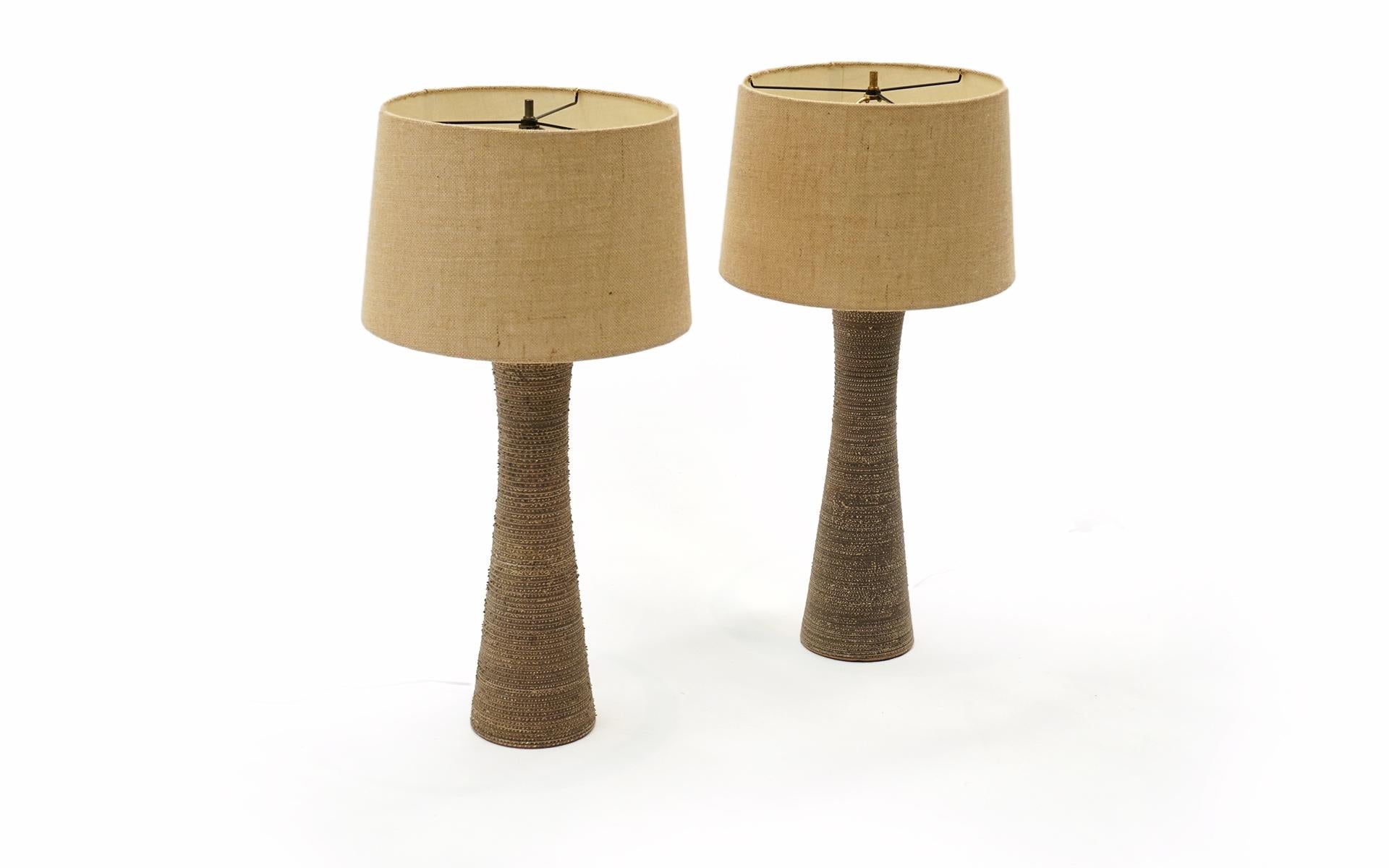 Pair of tall textured ceramic table lamps attributed to Gorden and Jane Martz for Marshall Studios. Unsigned. Very high quality materials and design. Taupe / grey / sand color. Original Shades. No chips, cracks or repairs. Working and ready to use.