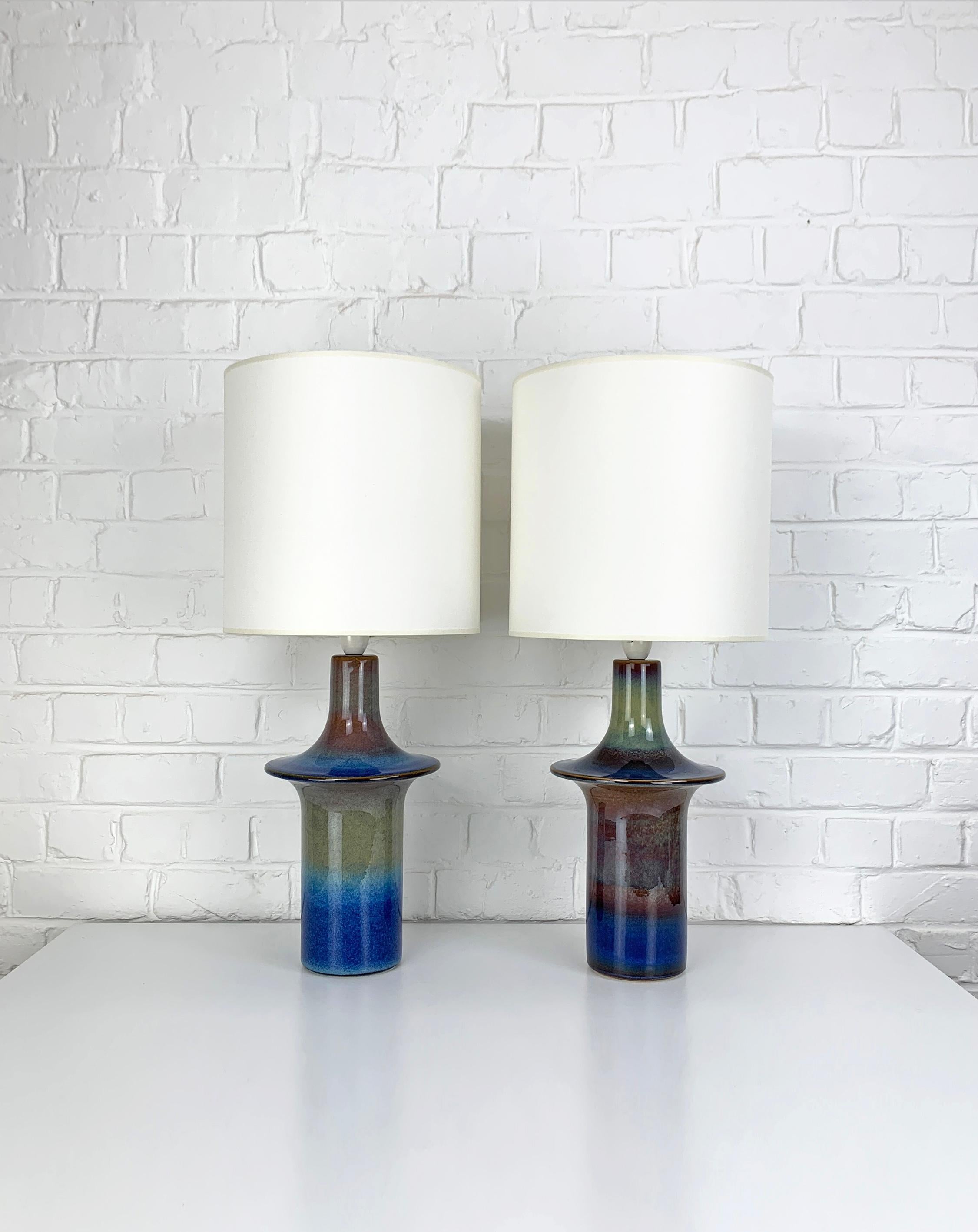 Paar hohe dänische Mid-Century Keramik-Tischlampen aus den 1960-70er Jahren. Glasiertes Steingut.

Skulpturale Lampenfüße im Ufo-Stil, blaue Glasur mit olivgrün-braunen Farbeffekten. Sehr seltenes Modell !

Modell Nr. 1070, hergestellt von Søholm