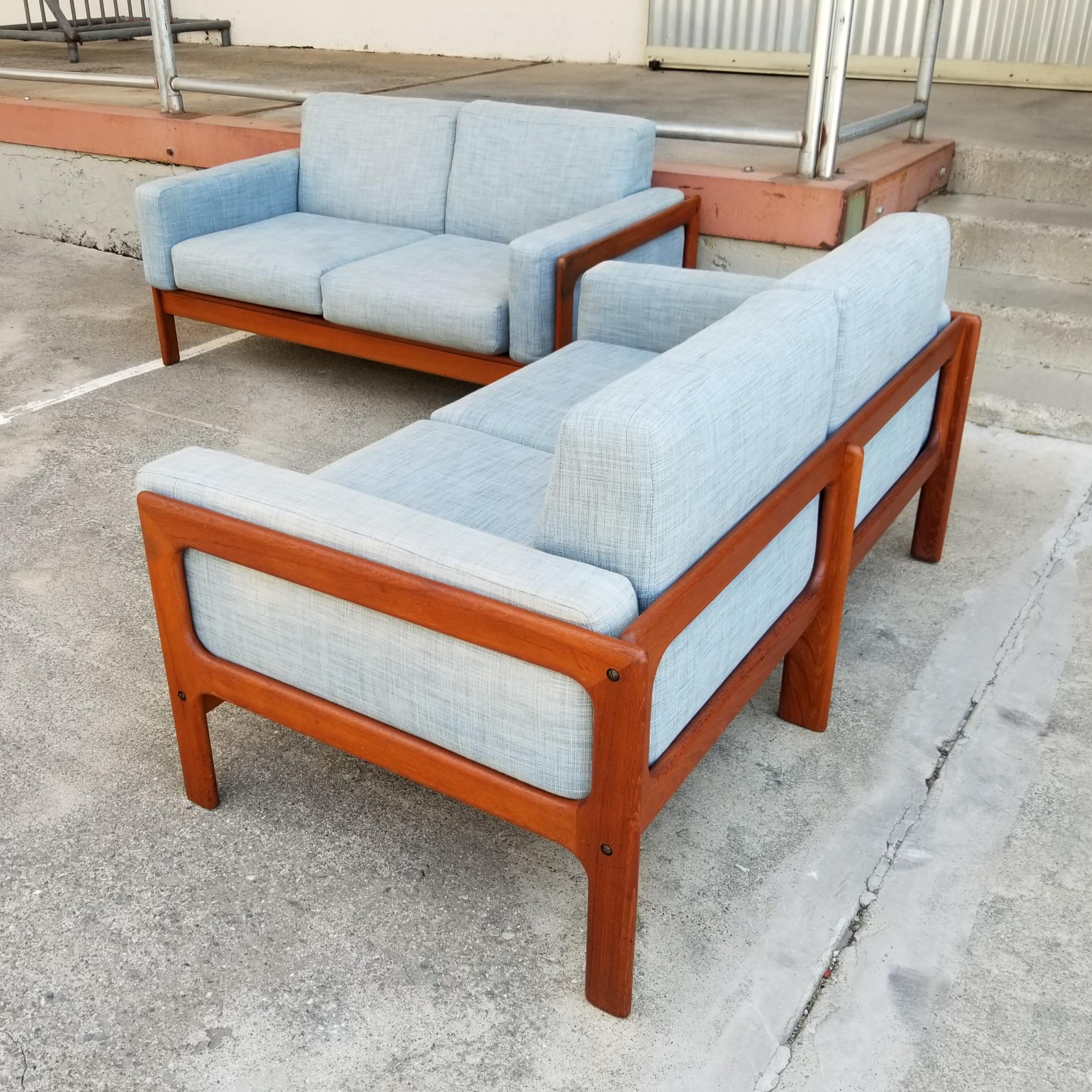 A matched pair of solid teak Danish Modern loveseats / two seat sofas. Very good original finish with older re-upholstery. Structurally very solid. Beautiful glow and patina to finish. Retaining Danish Control label. Similar to the open rectangular