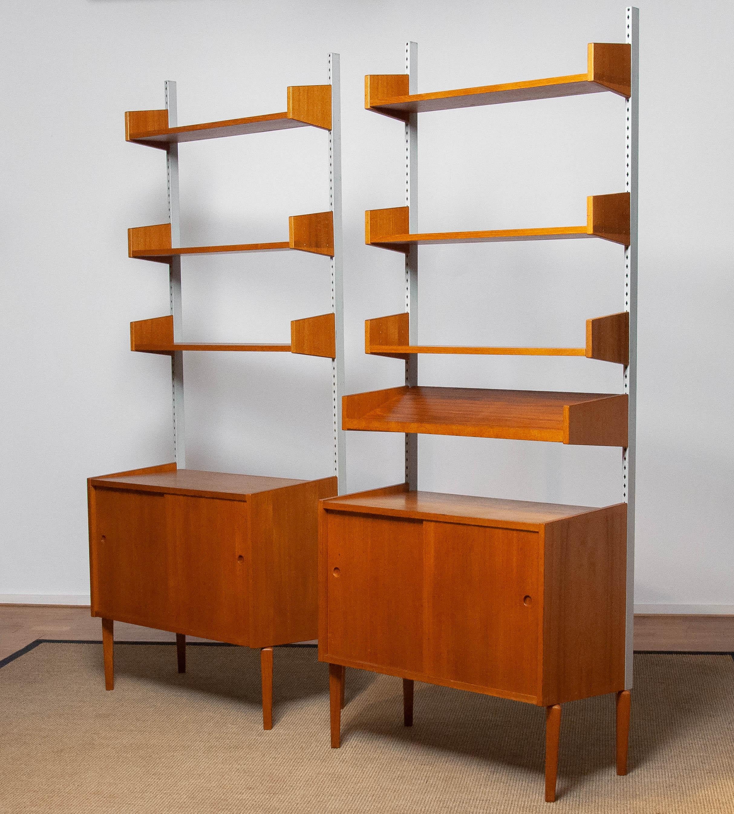 Beautiful and extremely rare pair modulair shelf systems designed by Harald Lundqvist for Lizzy Element Möbel Sweden from the 1950's. The three top-shelfs are adjustable in hight as well as the presentation shelf. The cabinets both have two sliding